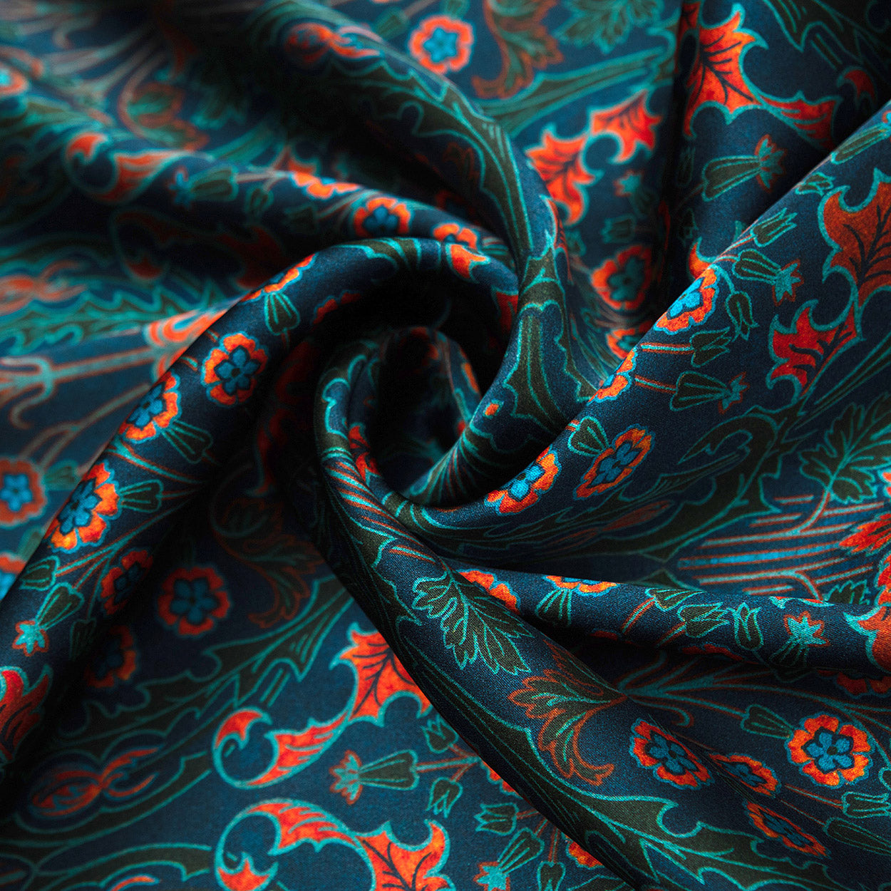 A close-up of the Floral Print Silk Scarf in Teal and Red Nature, showcasing intricate Art Nouveau floral patterns in teal, red, orange, and blue with vibrant swirling folds and detailed designs.