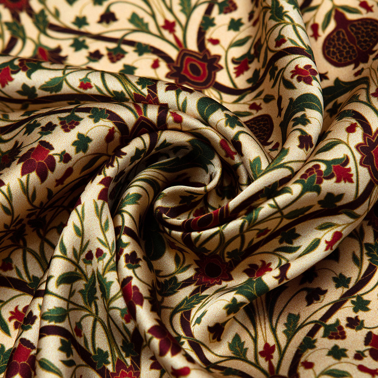 A close-up of the Art Nouveau Silk Scarf Berry shows its cream silk fabric with swirling folds and a floral print in green, red, and brown, featuring delicate vines and stylized art nouveau flowers.