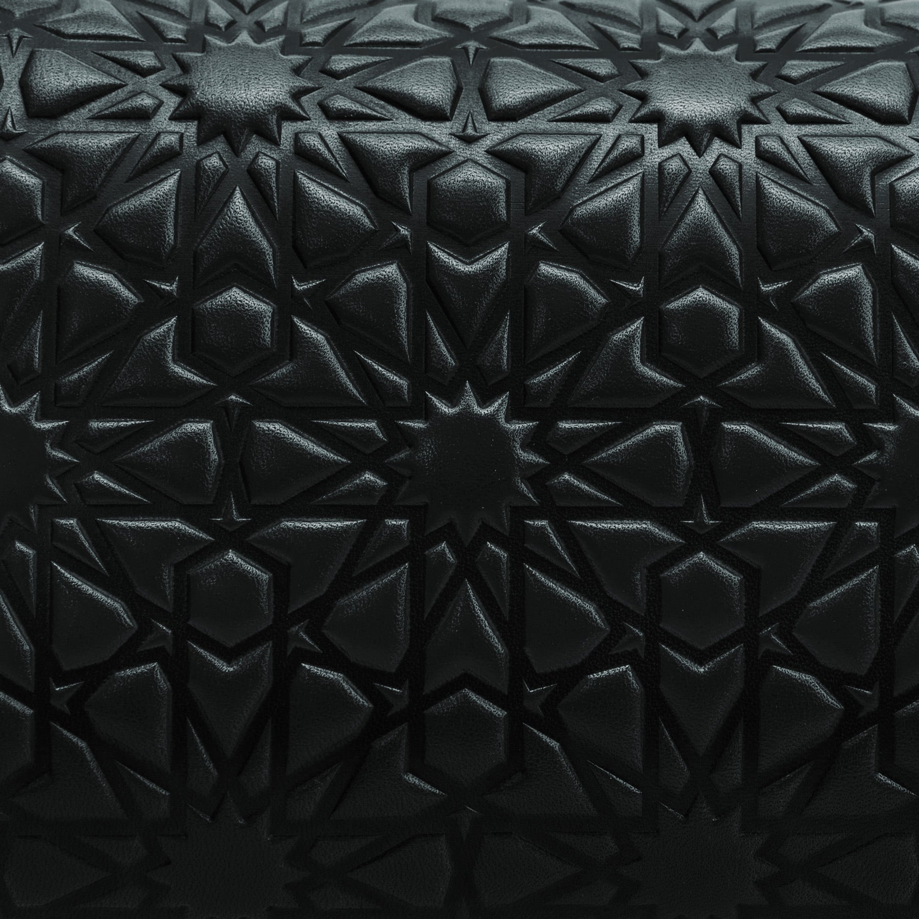 Close-up of the Small Black Leather Bag Bayarcal showing black vegetable-tanned leather with an Islamic-inspired embossed geometric pattern of repeating star shapes and interlocking lines for a textured, symmetrical design.