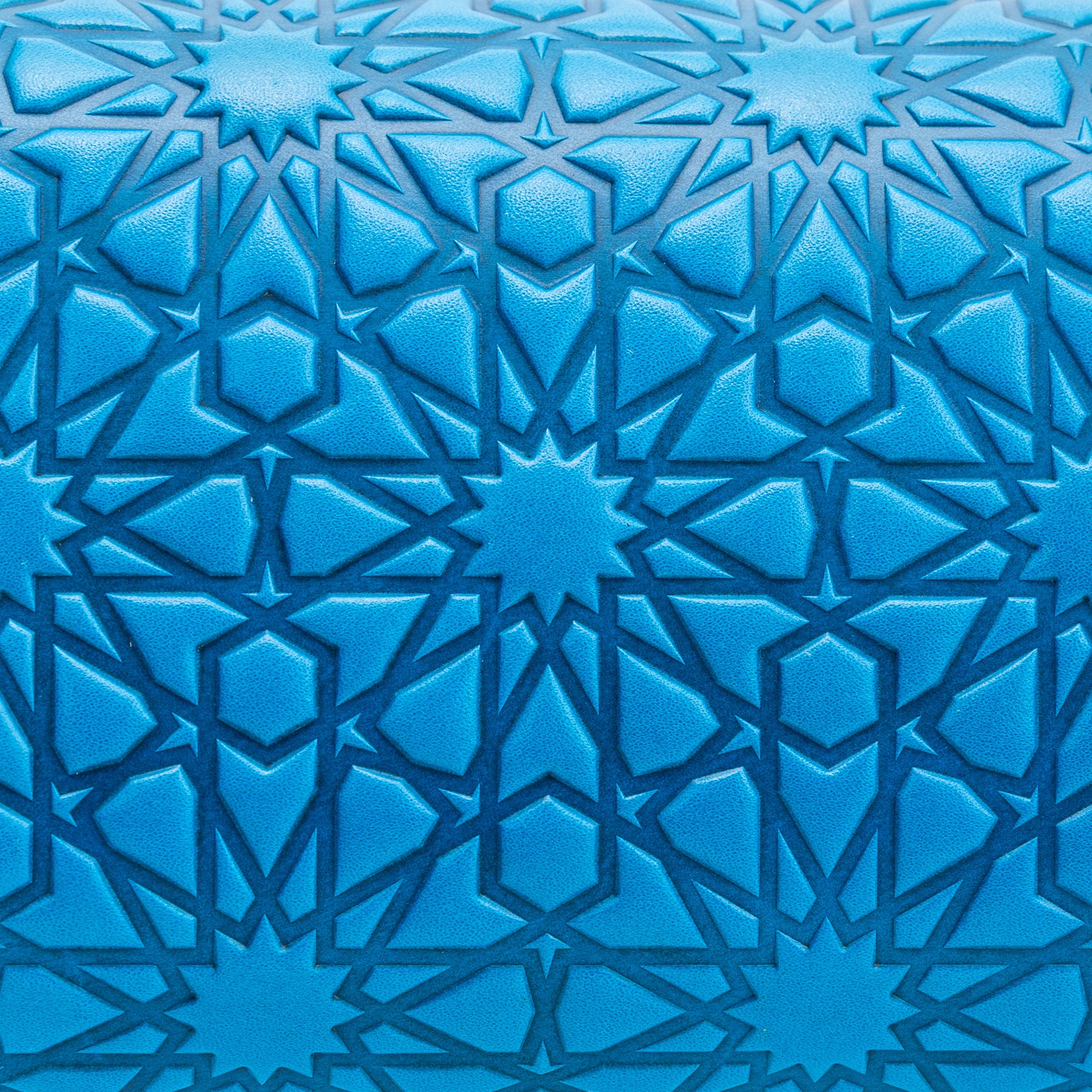 Close-up of the Blue Small Leather Bag Bayarcal, handmade in Spain with blue vegetable-tanned leather embossed in Islamic geometric patterns of interlocking stars and diamonds, evoking traditional tile designs and adding intricate visual depth.