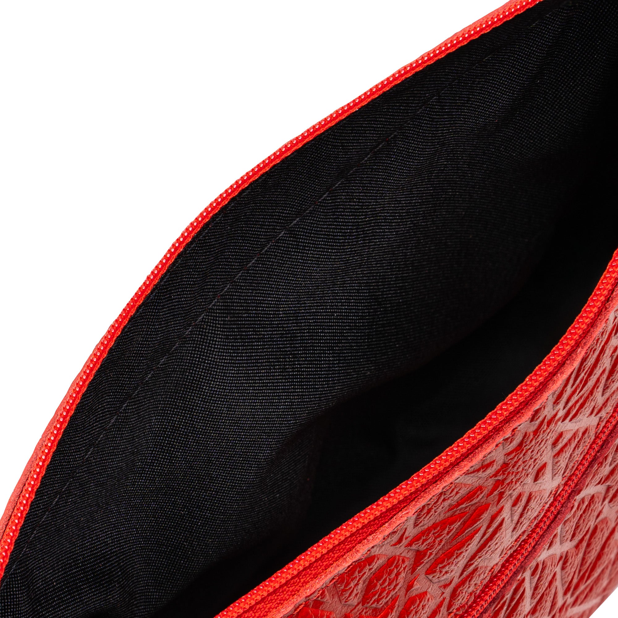 A close-up view of the Red Embossed Crossbody Bag with Islamic Design Pattern, highlighting its black fabric lining and detailed stitching inside.