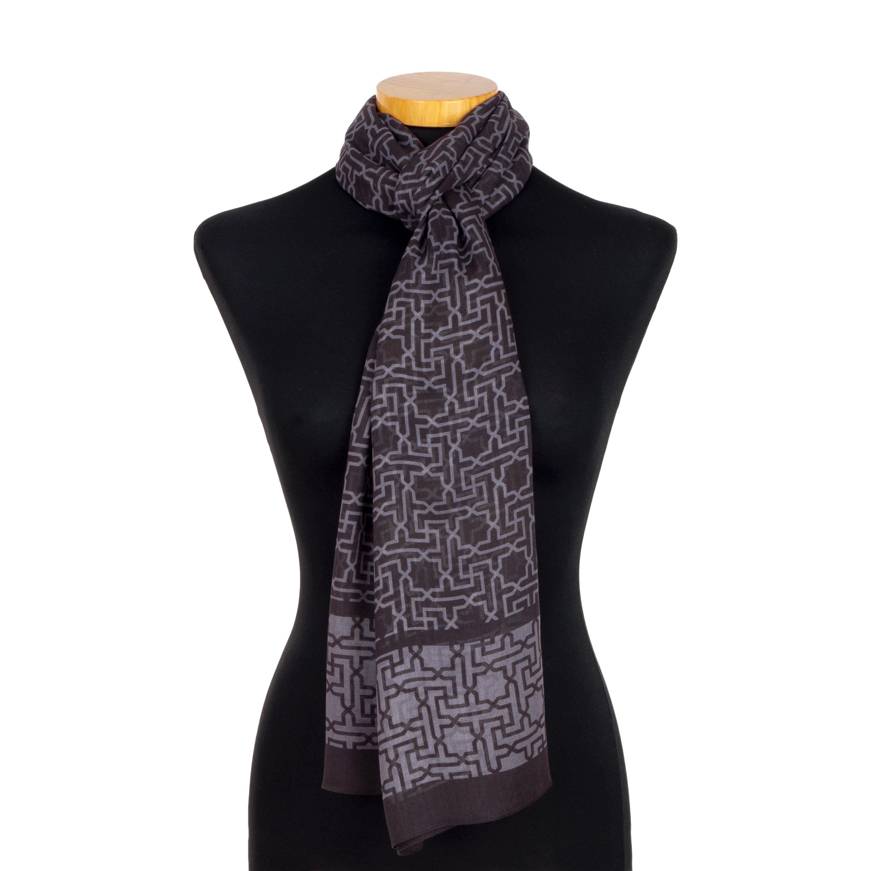 The Black and Gray Scarf Rawda v1, inspired by Alhambra motifs, is shown draped on a black mannequin—its minimalist design in contrasting grays makes it an elegant accessory and an ideal gift for travelers.