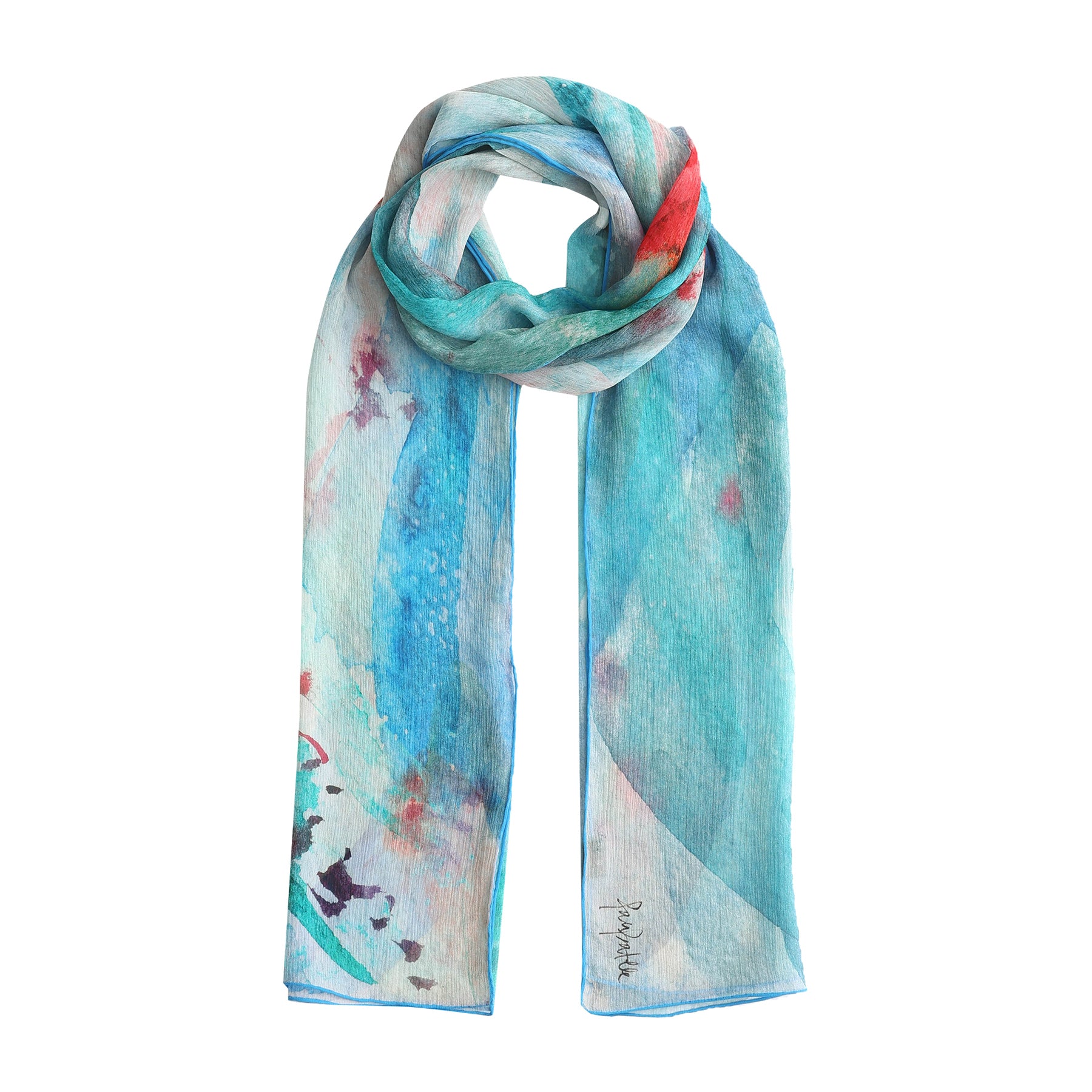 The Blue Silk Foulard Mediterráneos features lightweight muslin silk with a watercolor-inspired design in blue, teal, and red—an effortless Mediterranean accessory for stylish, easy draping.