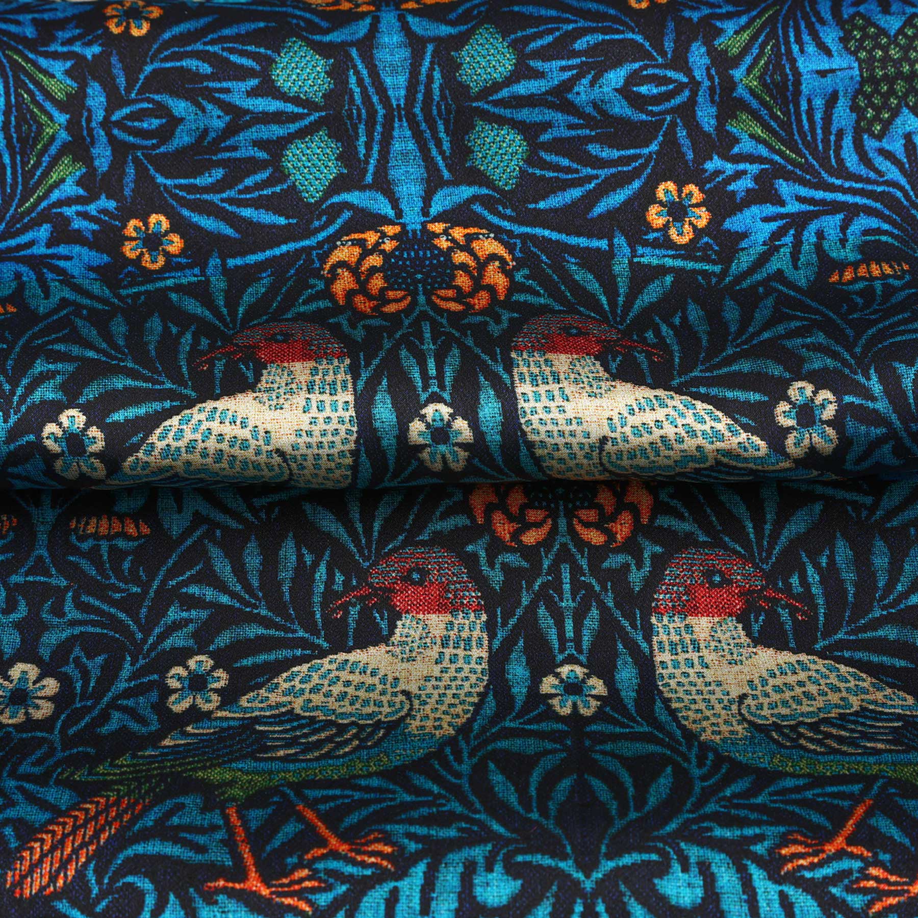A rectangular package with HAMZAH at the top, a William Morris Inspired Silk Scarf featuring vibrant blue and green bird and floral motifs in the center, and Wrap yourself in elegance at the bottom.