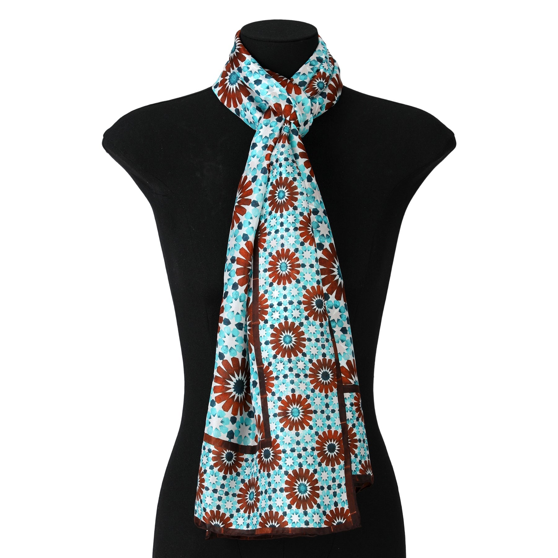 A black mannequin displays the Brown and Blue Silk Scarf Layla, featuring a red and brown geometric print, neatly tied around its neck.