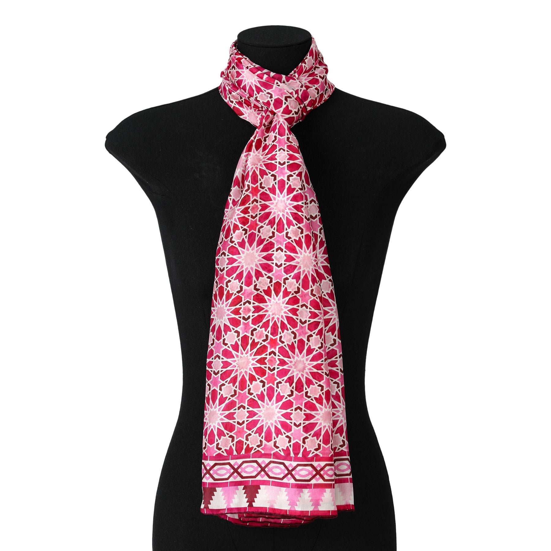 A mannequin showcases a Large Pink Silk Scarf with Zelig Print, featuring geometric borders and a stylish drape around the neck, flowing elegantly down the front.