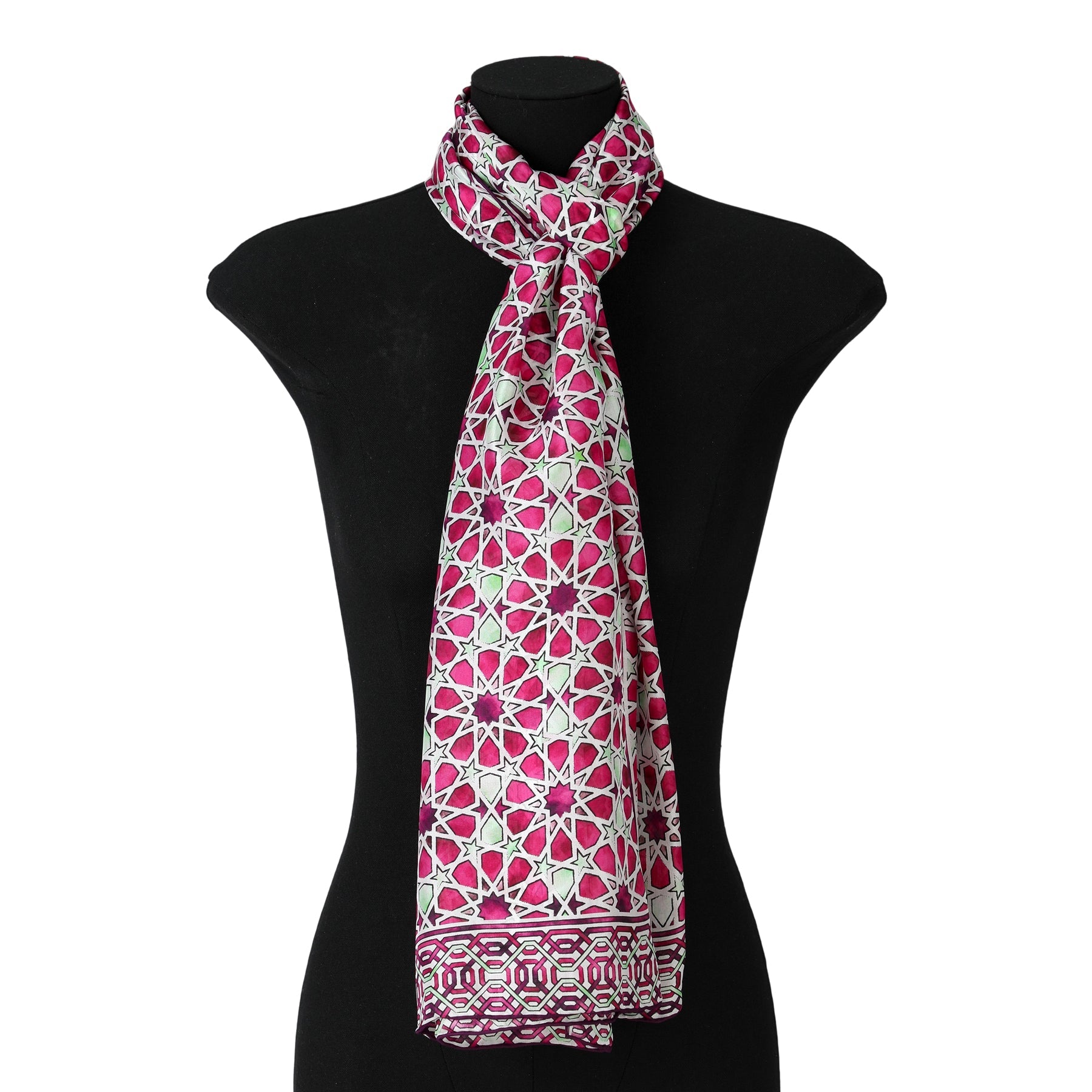 A mannequin displays the Long Pink Silk Scarf Fatima, featuring intricate pink, white, and green mosaic-inspired geometric floral designs, tied loosely around the neck.