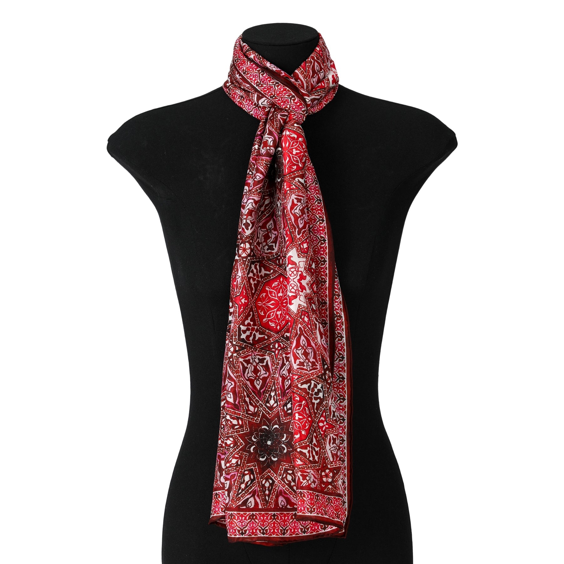 The Red Silk Scarf with Geometric Turkish Print, crafted from luxurious silk, is elegantly styled around the neck of a black mannequin bust.