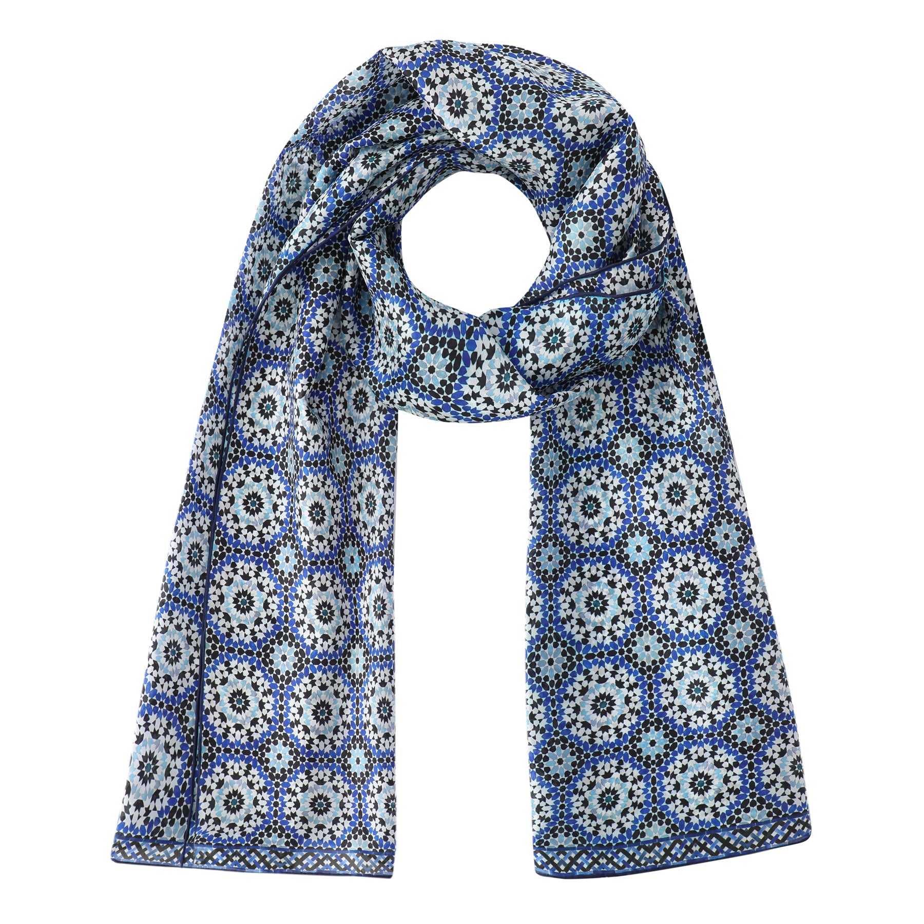 The Moroccan Tiles Inspired Silk Scarf Masdar features detailed blue, white, and black geometric Moroccan prints in circular floral designs. The silk scarf is displayed flat with one end looped at the top center.