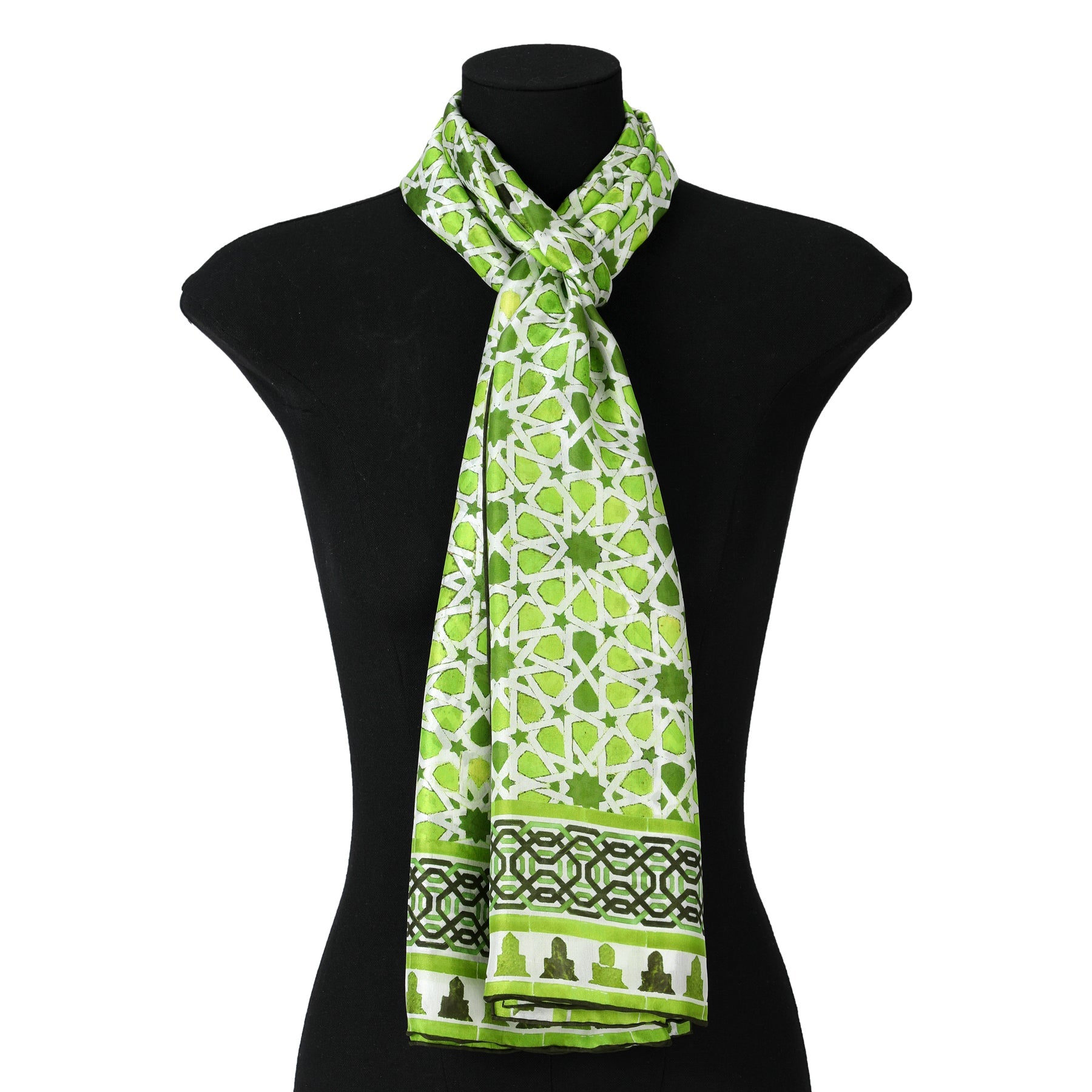 The Green Silk Scarf Islamic Art Print Partal, featuring green and white patterns with a dark green geometric border inspired by Islamic art, is draped around the neck of a black mannequin torso.