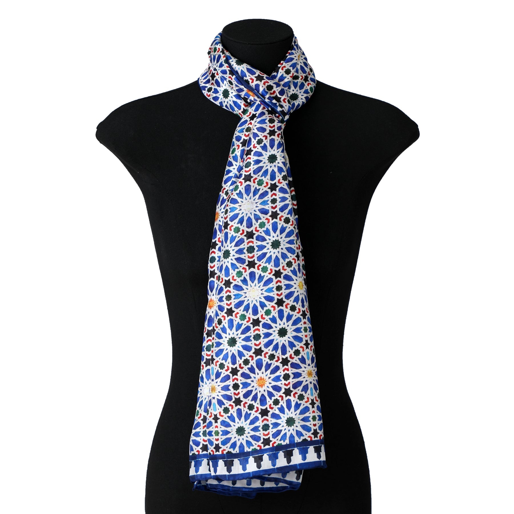 A mannequin torso displays the Islamic Art inspired Silk Scarf Zellige, featuring a vibrant geometric floral pattern in blue, white, yellow, and red, draped neatly around the neck.
