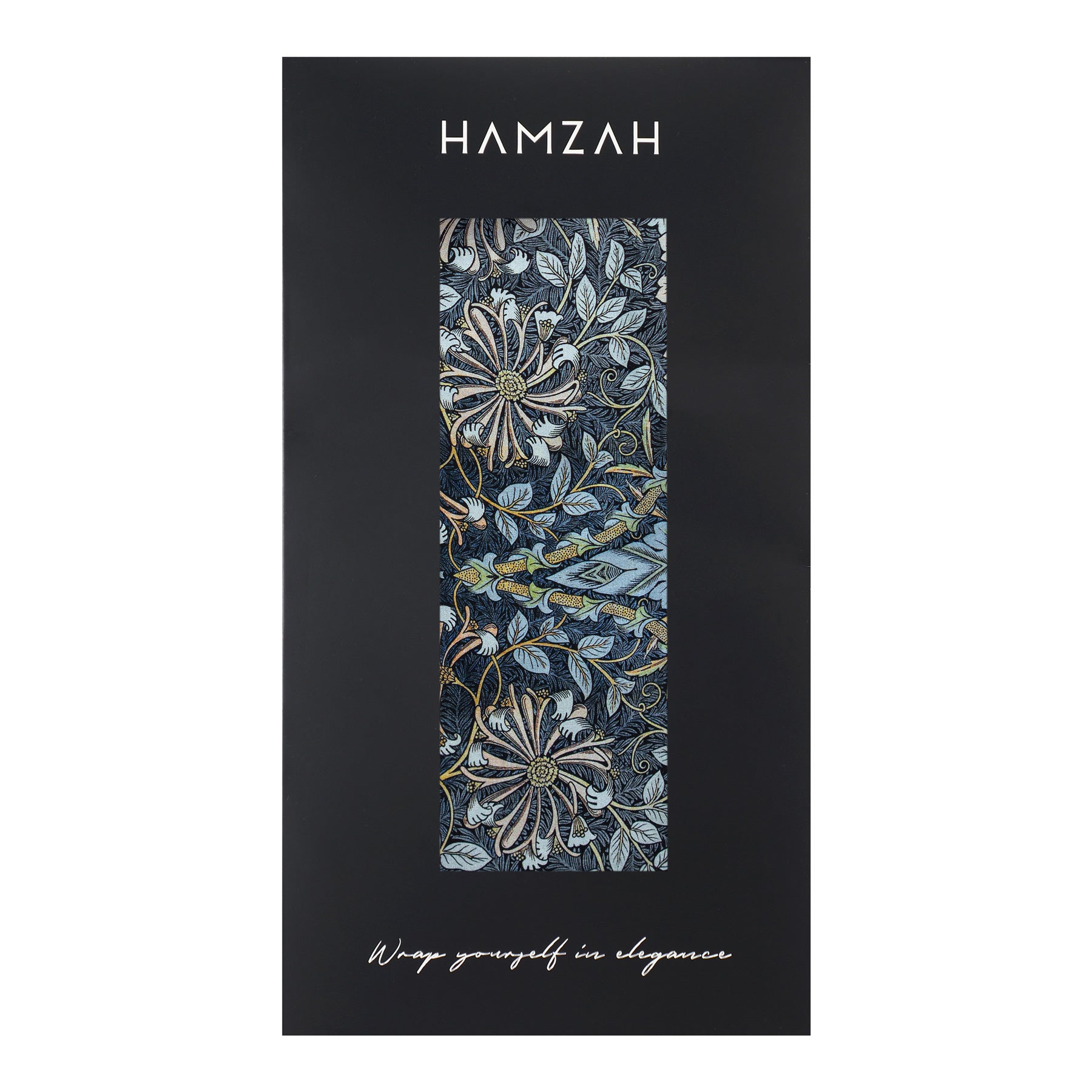A rectangular black box with a clear window displays the Grey Silk Scarf Erna. The box reads HAMZAH at the top and Wrap yourself in elegance at the bottom.