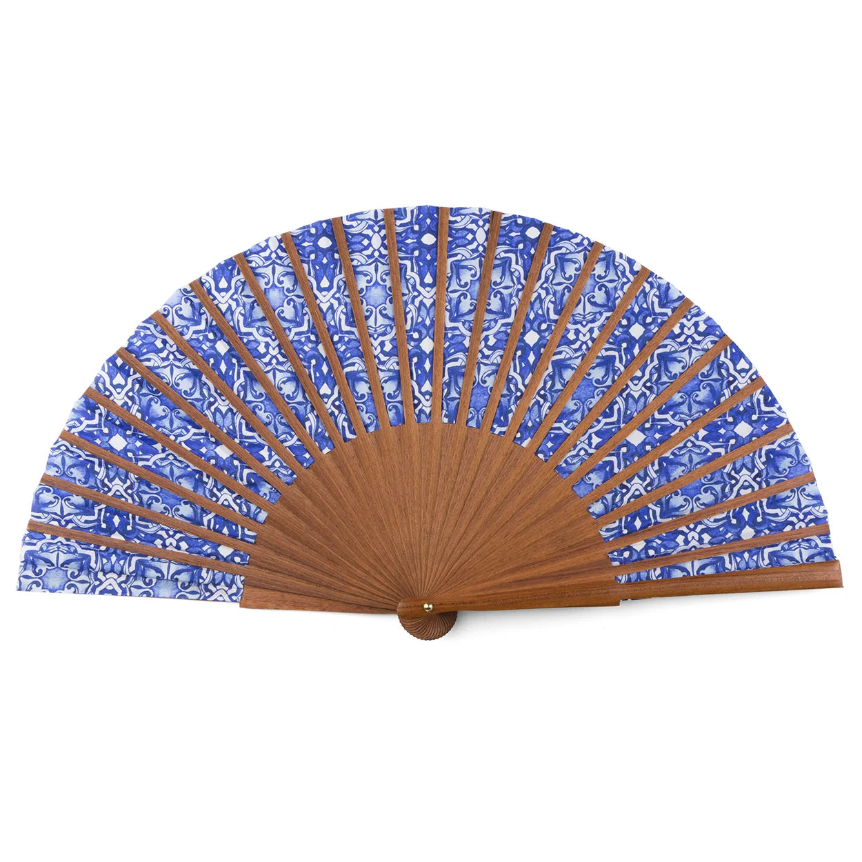 The Blue folding hand fan Farah features blue and white patterned fabric inspired by Spanish tiles and abstract florals, with wooden ribs and base. Made in Spain, it is shown fully open against a white background.