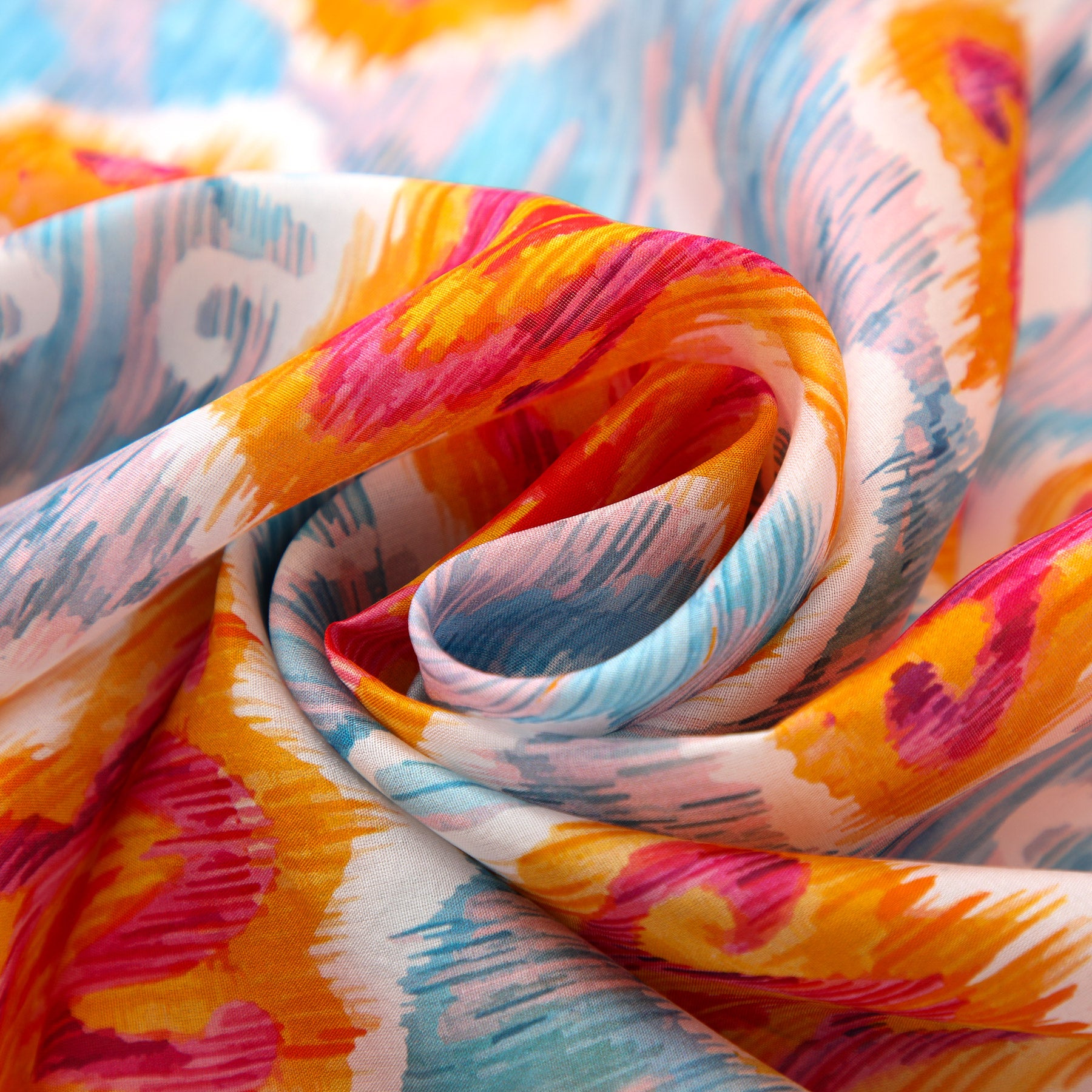 Close-up of a Light Blue Silk Scarf with Ikat Print, featuring swirling folds and vibrant brushstroke designs in orange, red, yellow, blue, and pink on a white background inspired by Indonesian ethnic patterns.