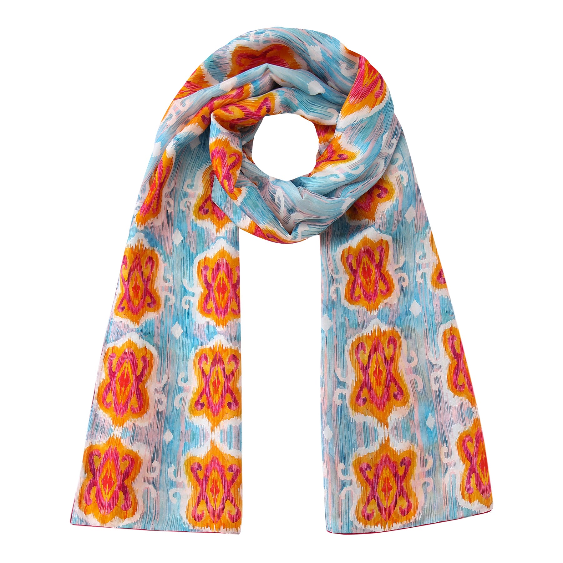 The Light Blue Silk Scarf with Ikat Print showcases bold orange, yellow, and pink shapes in a symmetrical Indonesian-inspired pattern, crafted from silk and displayed in a loose loop with both ends hanging down.