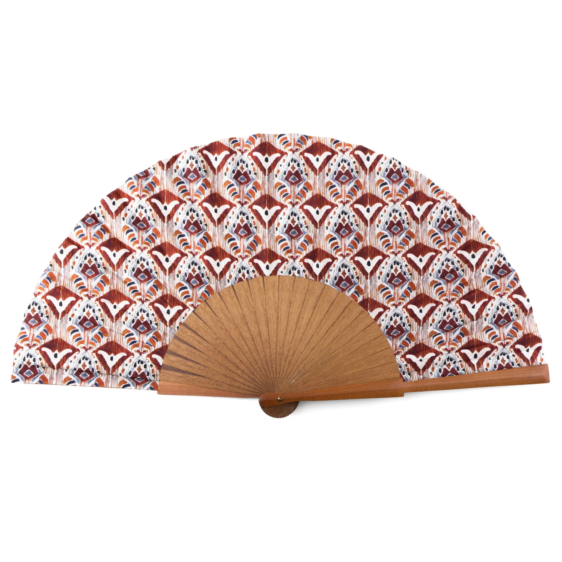 A handcrafted silk fan with a vibrant Ikat-inspired design in orange, red, and blue tones, paired with a sturdy Bocapi wood handle. The fan is 23 cm wide when opened, and it is handmade in Valencia, Spain.