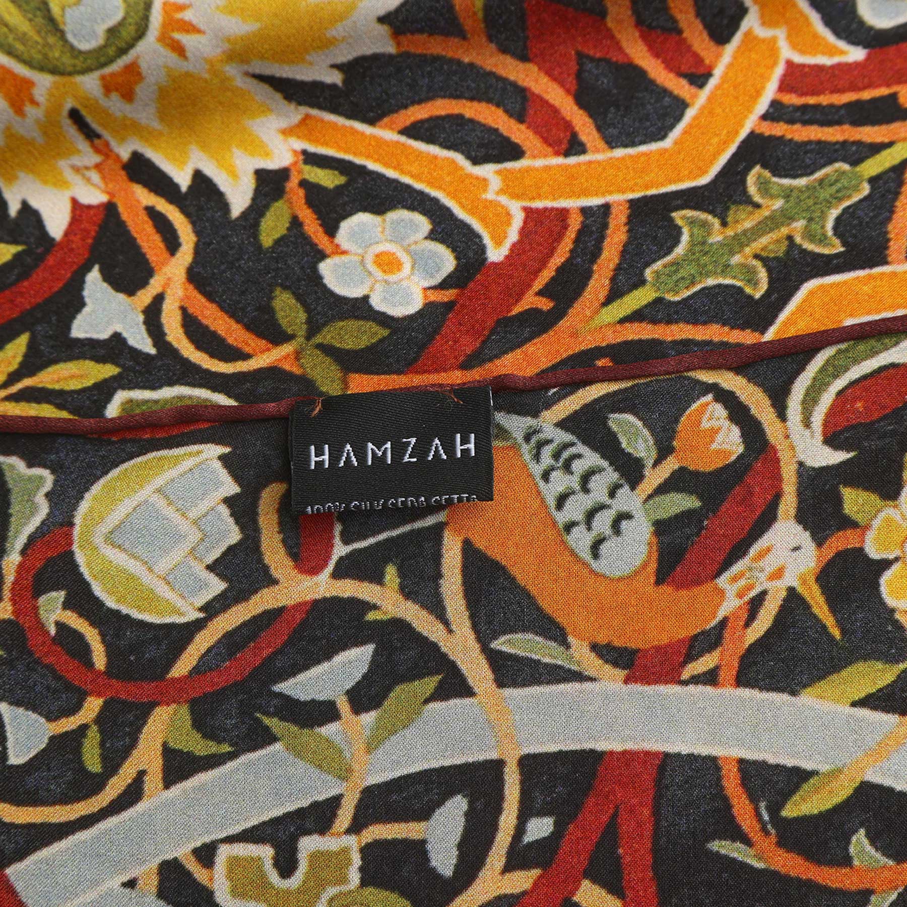 A black rectangular box with HAMZAH at the top, a central window displaying the Vintage Floral Silk Scarf featuring ornate bird & bloom motifs, and “Wrap yourself in elegance” written at the bottom.