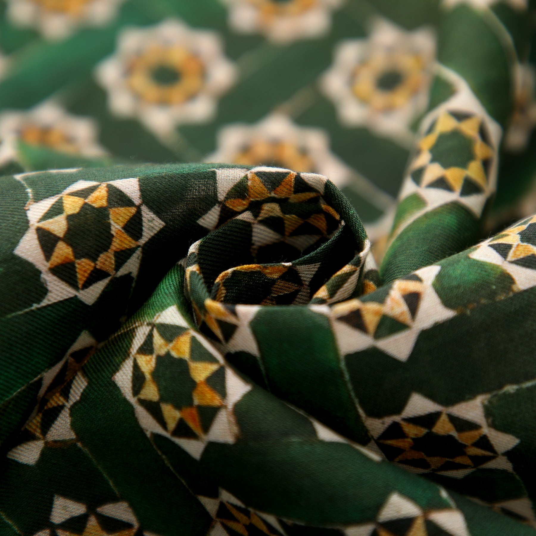 The Green Modal Scarf for Women Andalusí features a close-up of its fabric elegantly twisted, showcasing the texture