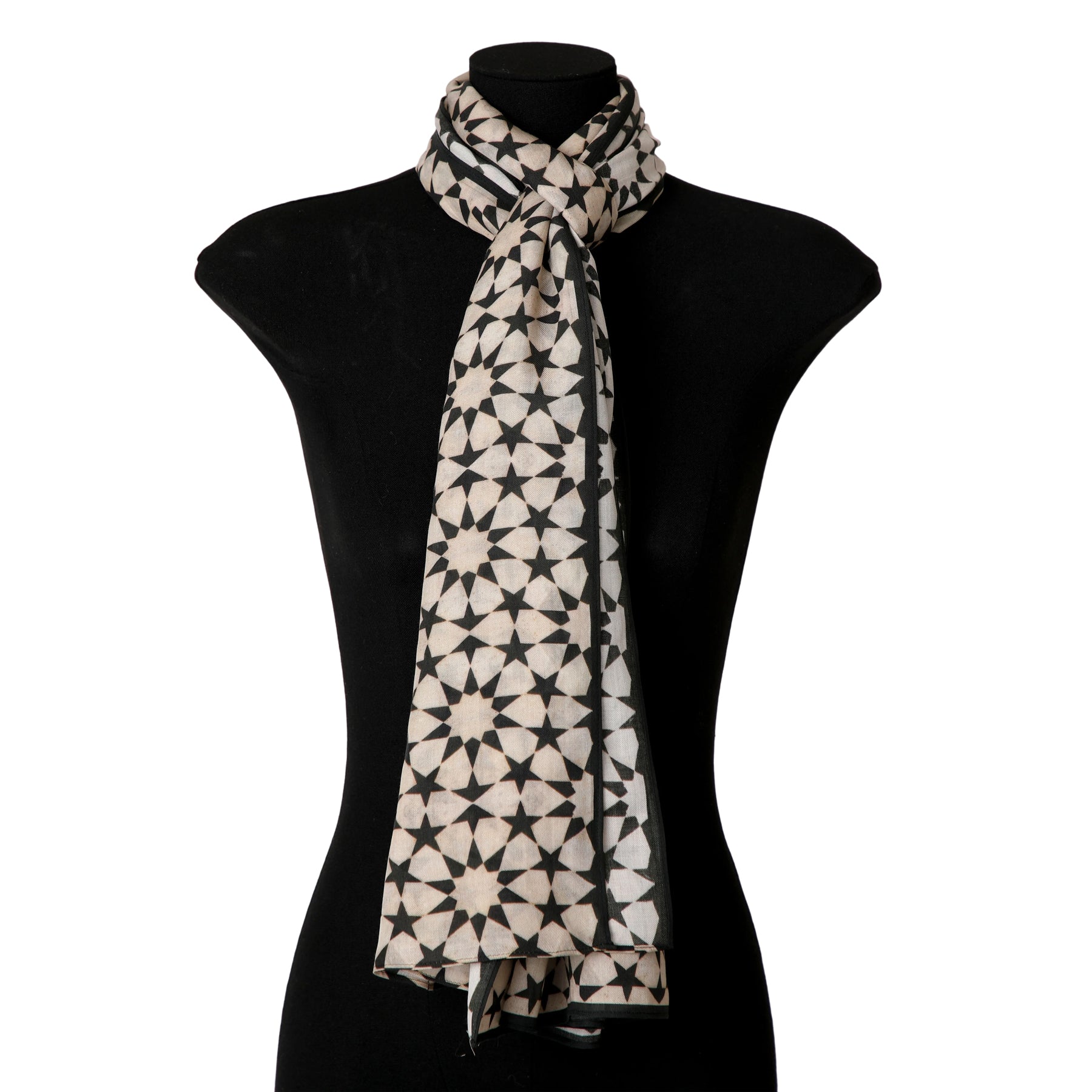 The Beige and Black Scarf - Sahara, inspired by Andalusí Islamic art, is draped around a black dress form mannequin to highlight its intricate geometric pattern and soft modal fabric.