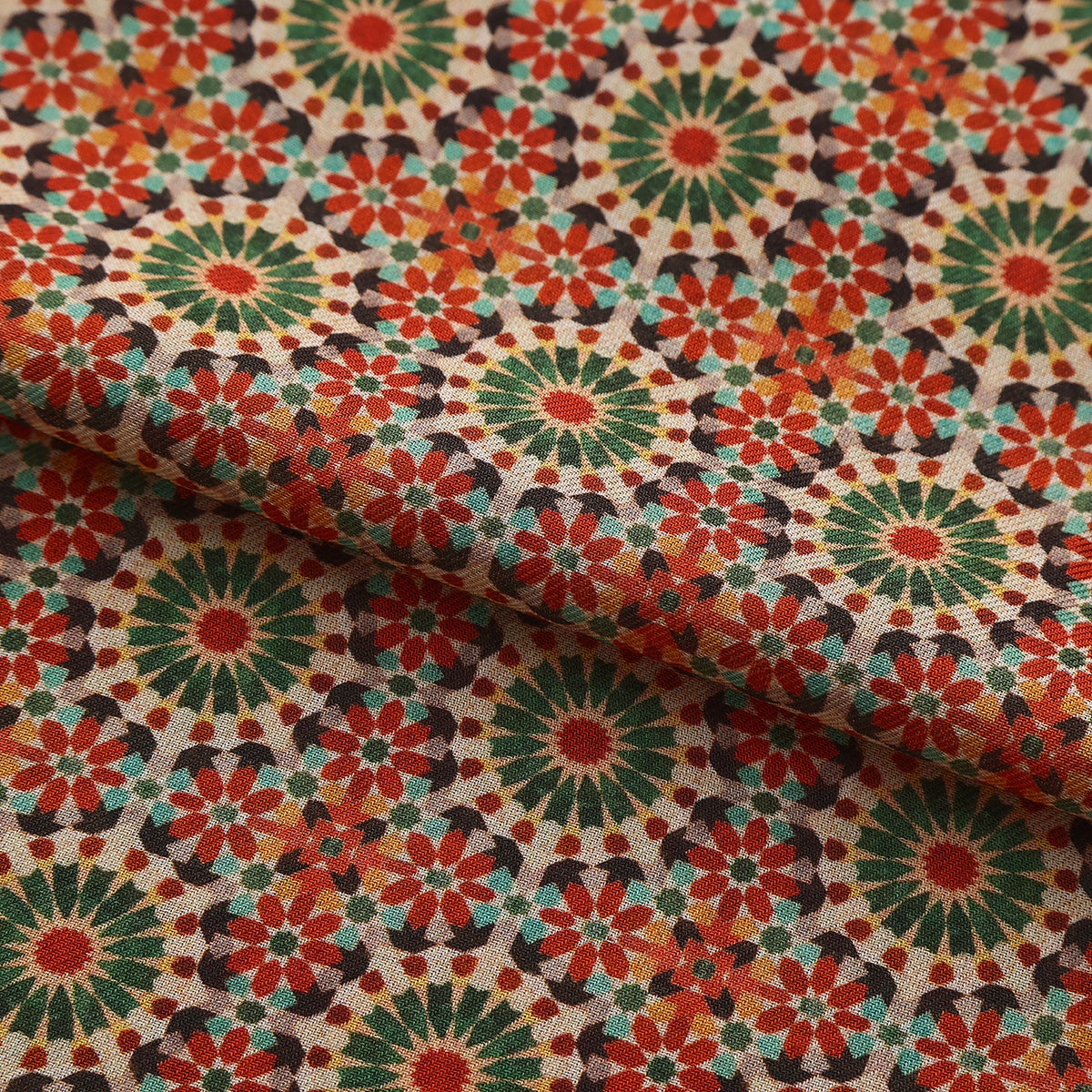 Folded fabric detail of the Red and Green Modal Scarf Mosaic Rosettes Zubaida, showing the terracotta and green rosettes on sand