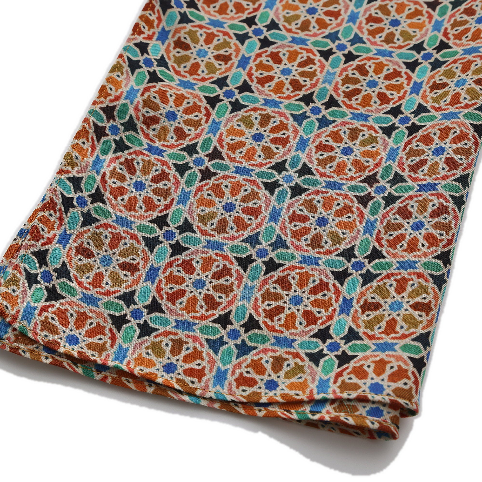 Folded corner of the Orange Modal Scarf Mosaic Wheels Wallada, showing the border and the hem