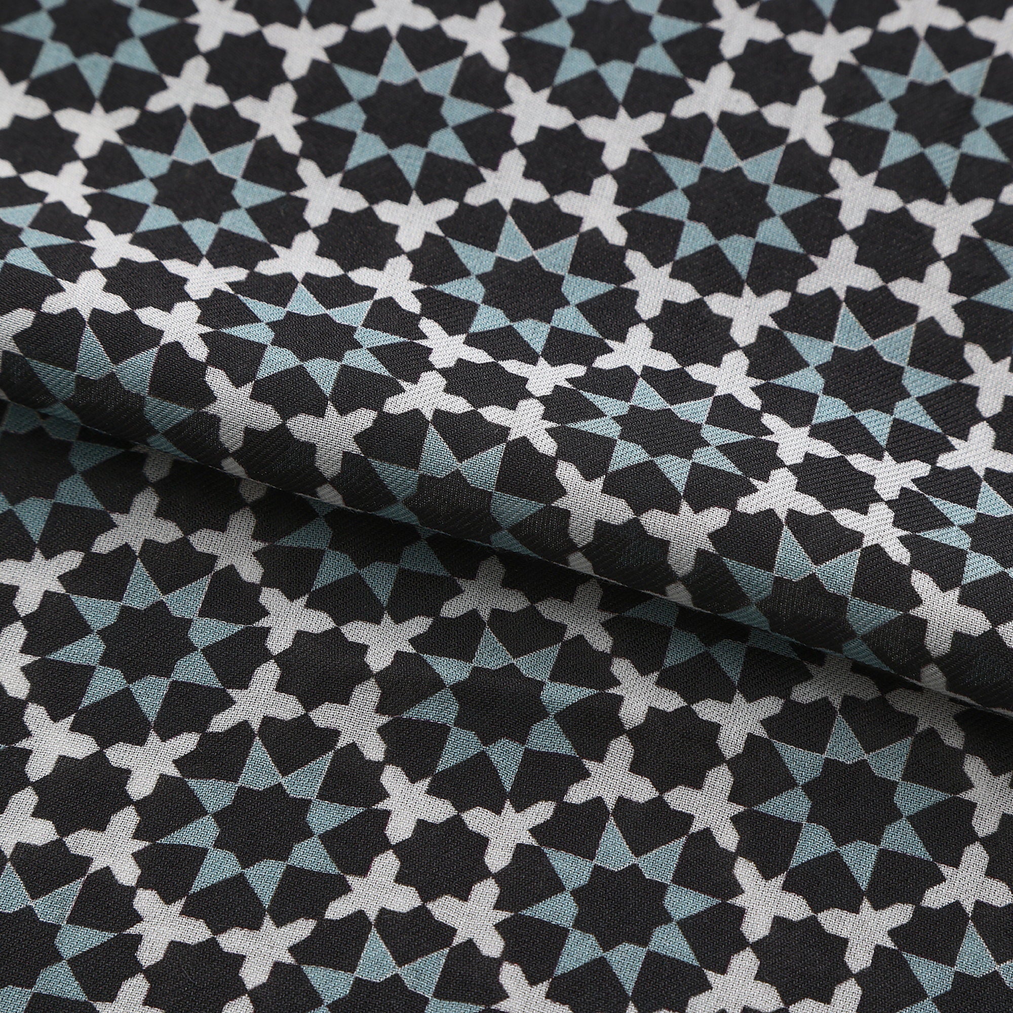 Folded fabric detail of the Black and Grey Modal Scarf Star Lattice Zoraida, showing the black and slate grey star lattice