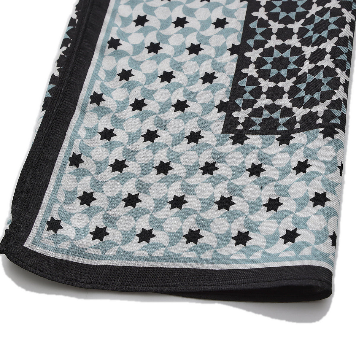 Folded corner of the Black and Grey Modal Scarf Star Lattice Zoraida, showing the border and the hem
