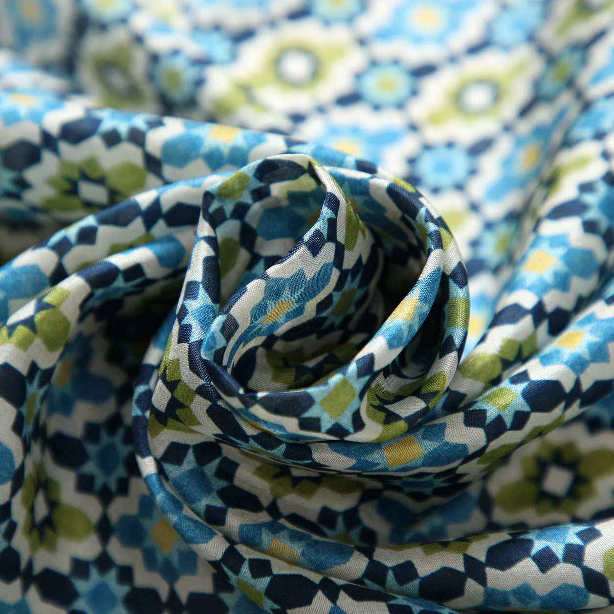 Close-up of the Ayad silk print: eight-pointed stars in sky blue, olive and cream on a navy ground