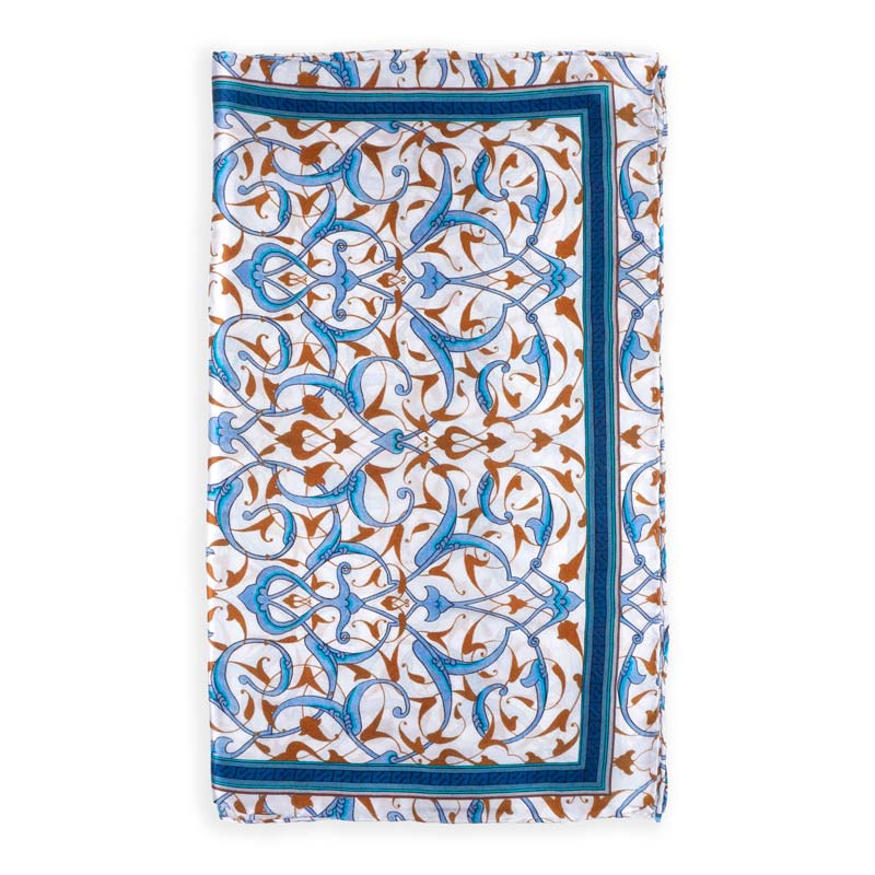 Hamzahs Blue and White Silk Scarf with Turkish Print Rumi features intricate, symmetrical patterns with blue and brown ornate designs on a white background, bordered by a thick black line. The motif exudes classical artistry and elegance.