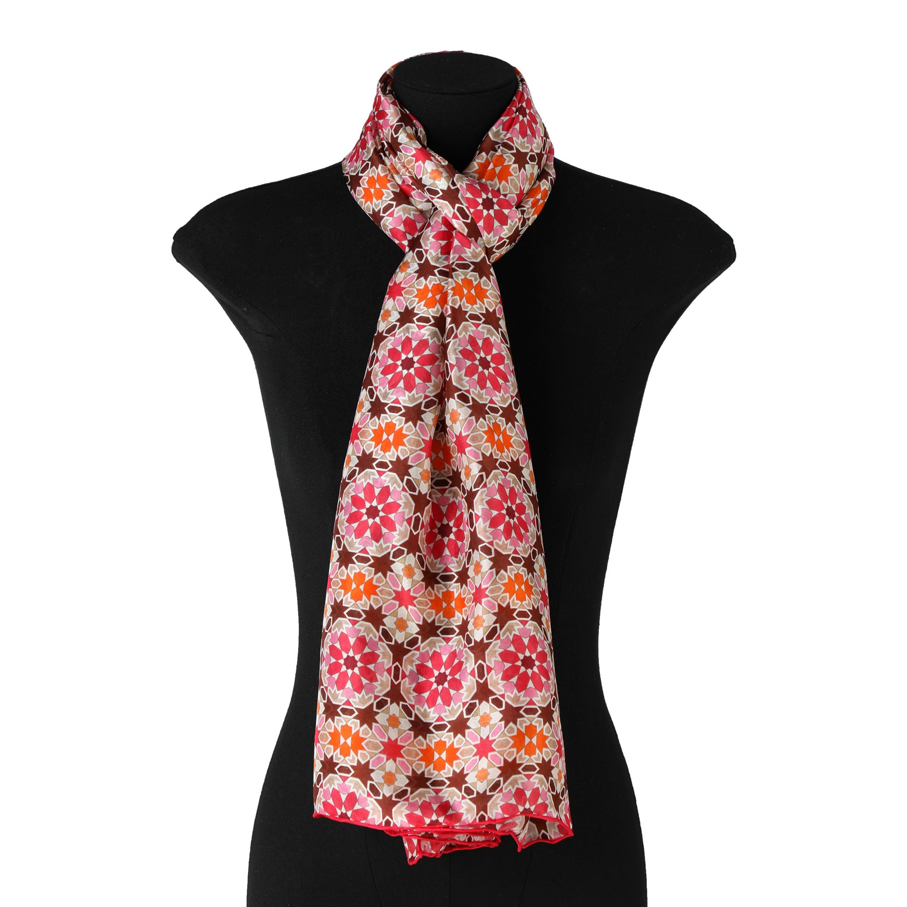 A mannequin displays the Sacred Geometry Pink Silk Scarf Mashrabia V1, featuring a vibrant Islamic Art-inspired floral pattern in red, pink, orange, and white, elegantly draped and knotted around the neck.