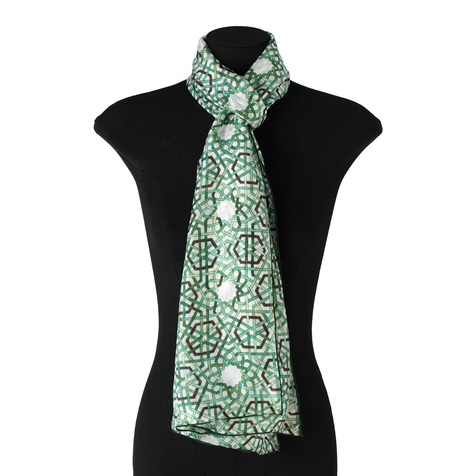 The Green Islamic Art Tessellation Silk Scarf Hijaz V2, featuring a green and white Islamic art pattern, is draped around the neck of a black mannequin bust with the ends cascading down the front.