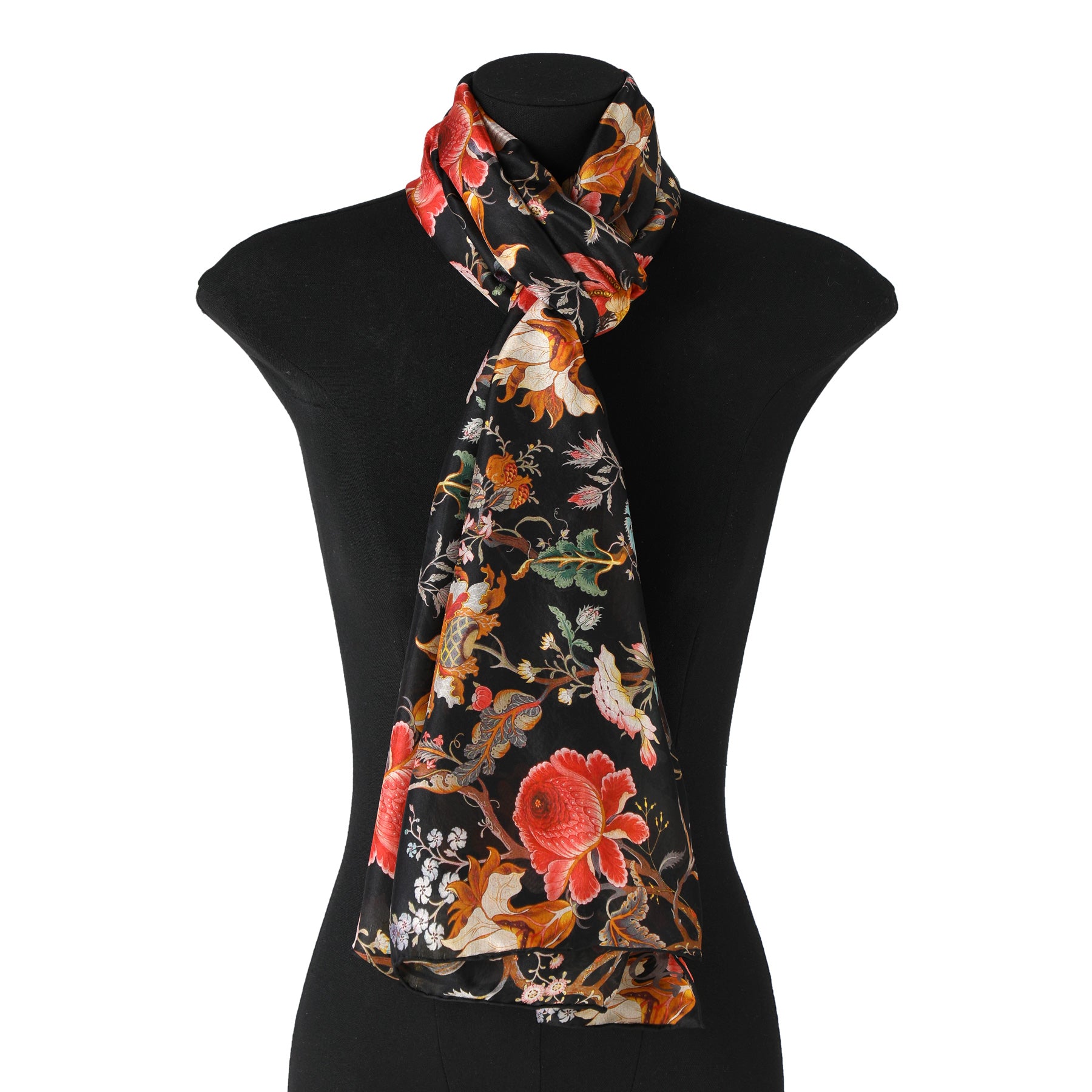 A mannequin showcases the Hamzah William Morris Silk Scarf Black Aubrey, featuring vibrant red and orange floral patterns with intricate green leaves and small white flowers, elegantly draped around the neck.