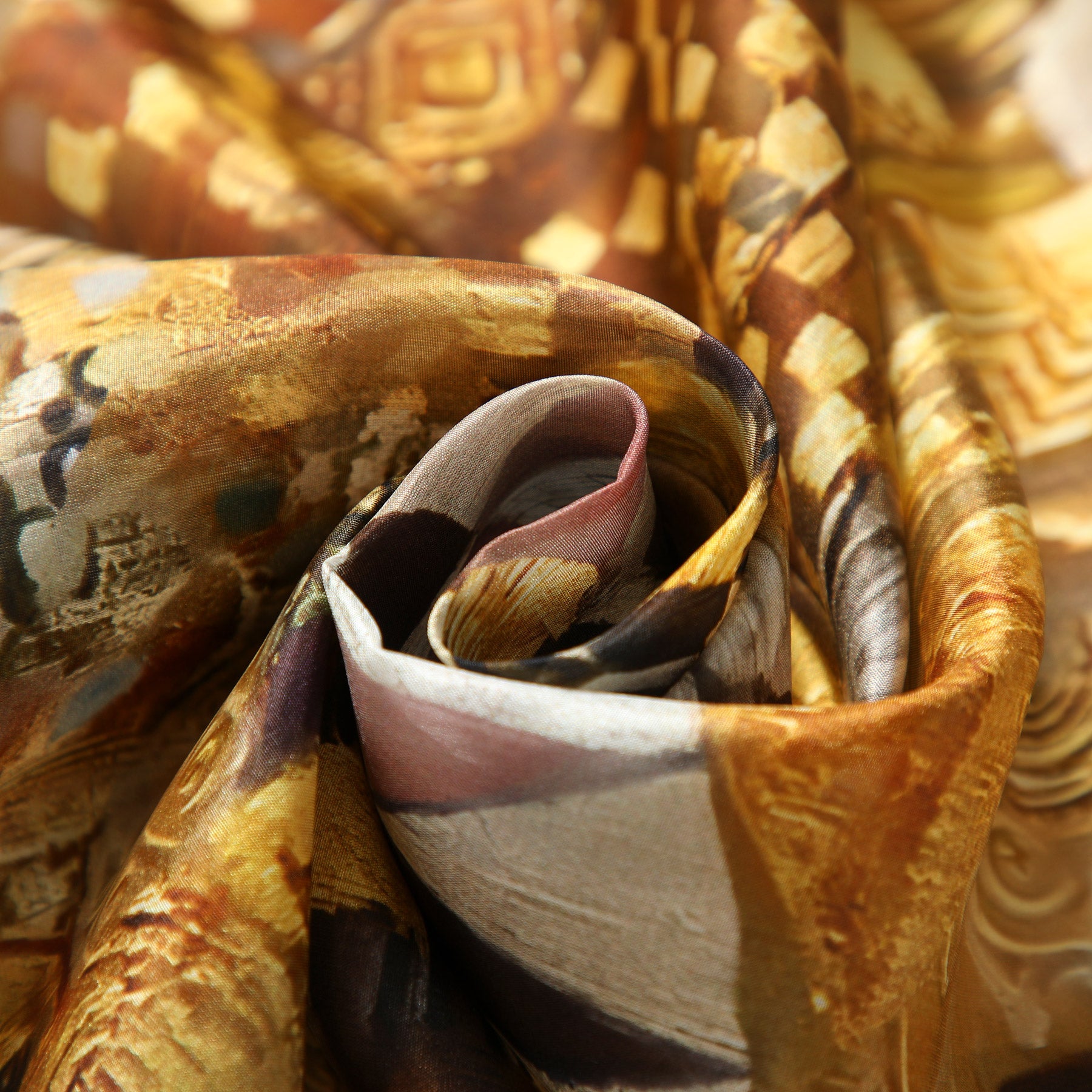 A close-up of the G. Klimt inspired Silk Scarf, featuring a silky brown and gold abstract pattern, artfully twisted into a rose shape, showcases its smooth texture and glossy finish.