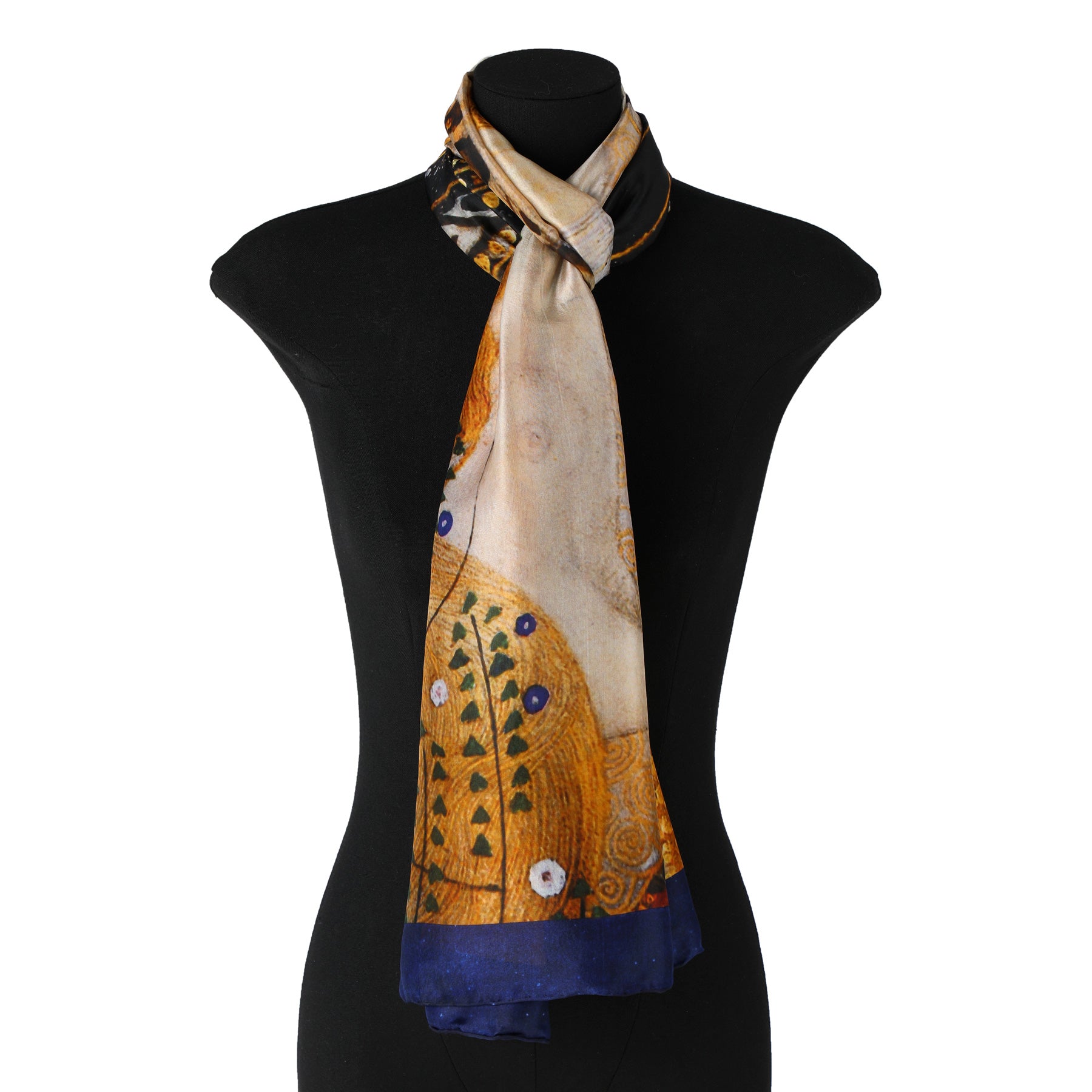 A black mannequin is adorned with Hamzahs Gustav Klimt Scarf Water Serpents II, made of Habotai silk. The scarf, in an abstract design with warm golds and blues, echoes Klimts artistry and is elegantly knotted at the neck.