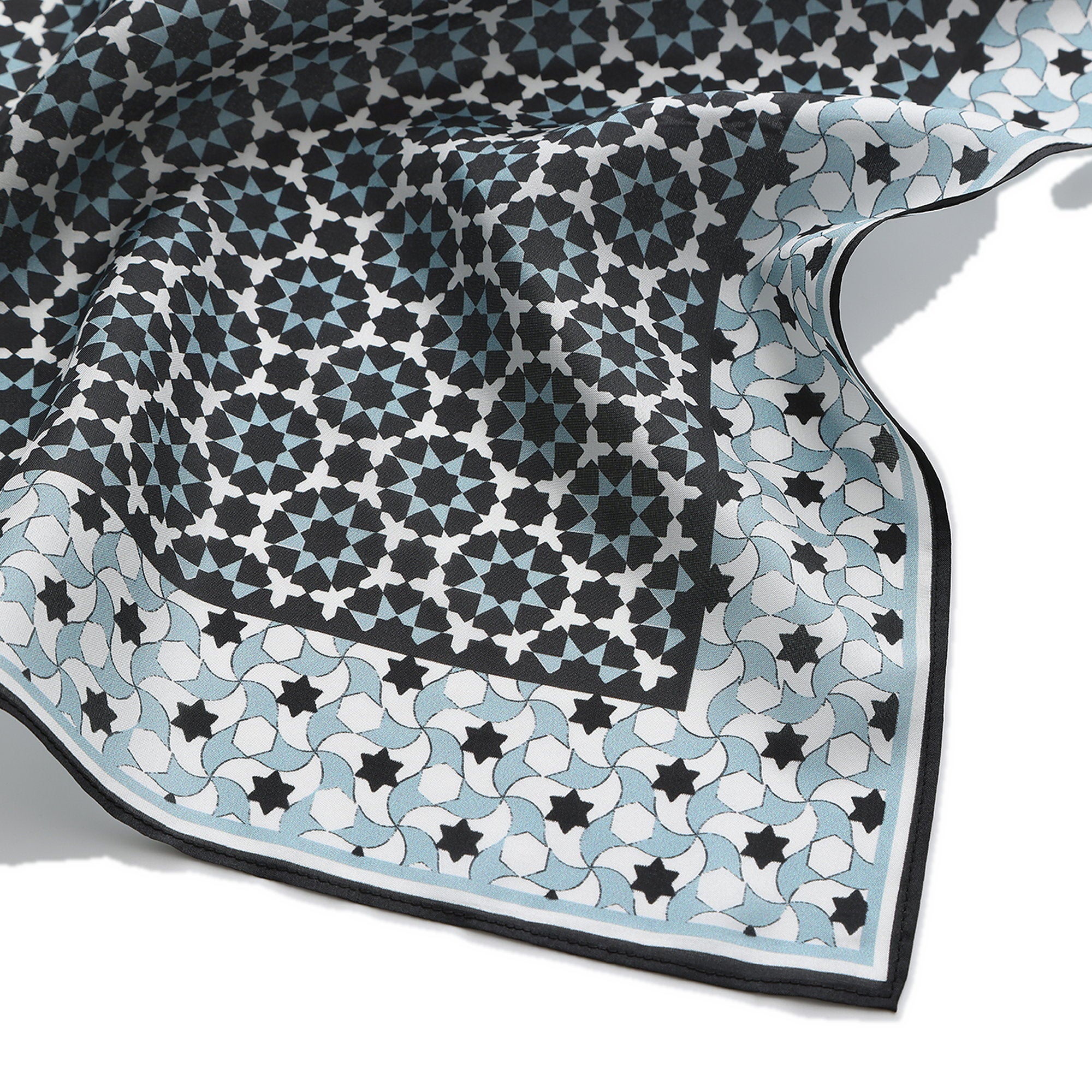 Close-up of the Zoraida silk print: the black star lattice and grey-blue border