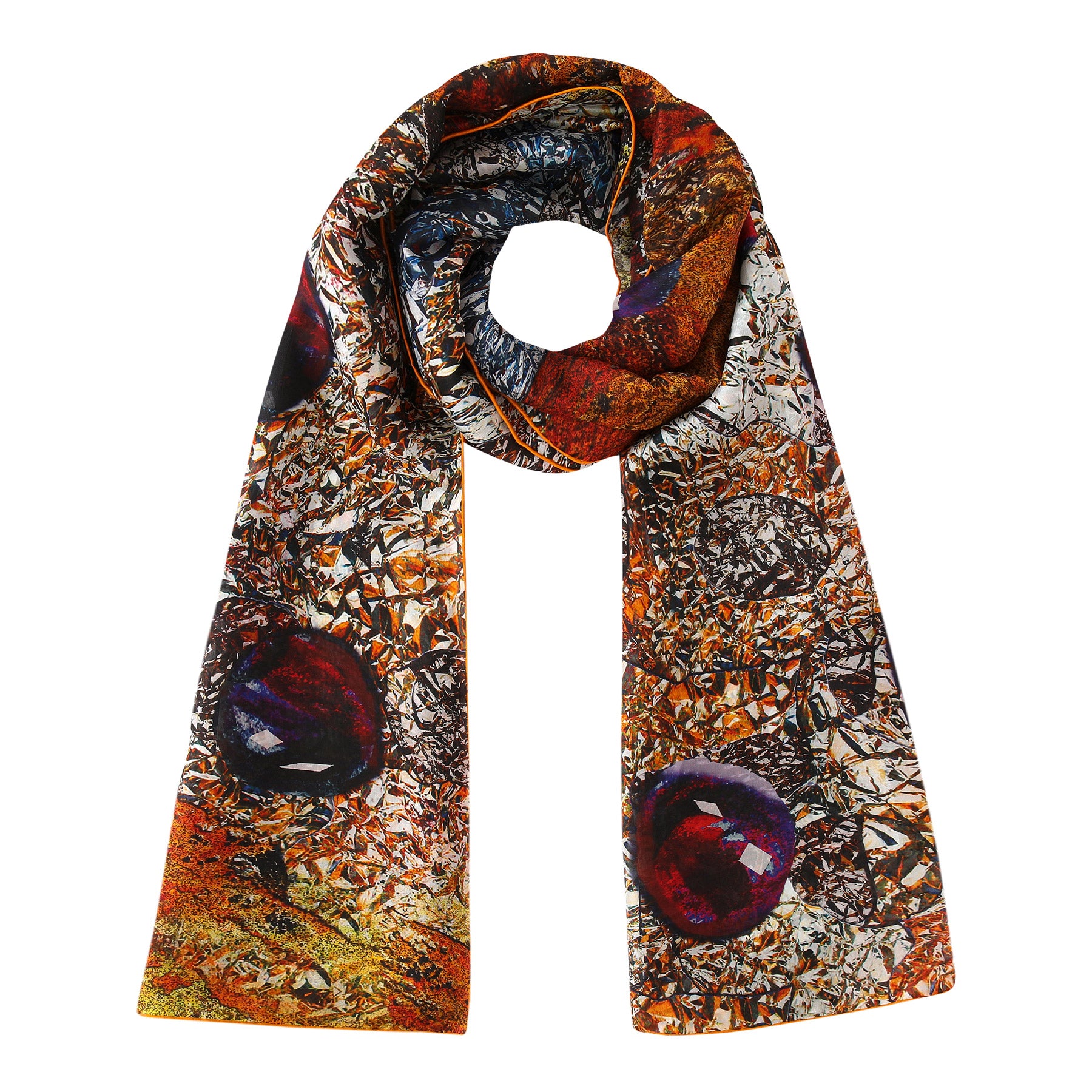 The Habotai Silk Scarf Corazón de Granada is a long, colorful wearable artwork with swirling orange, brown, and silver abstract patterns, accented by large, round dark red and purple shapes.