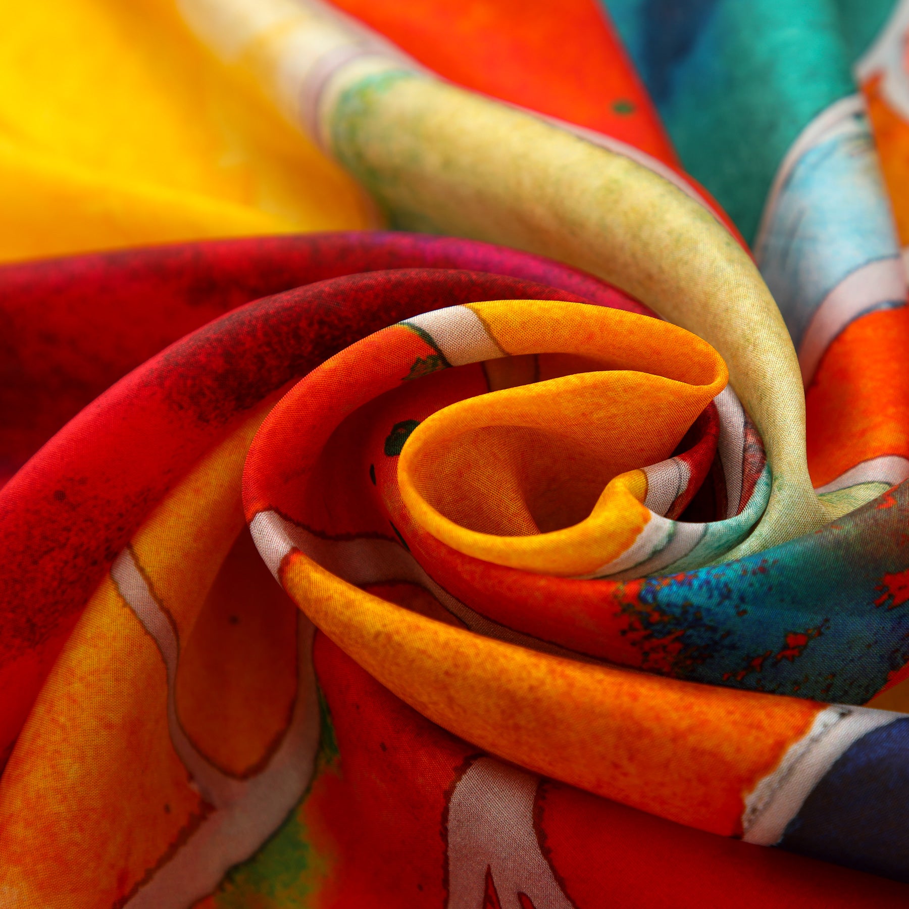 A close-up of the Multicolor Silk Shawl for Women, swirled into a spiral, showcases vibrant red, orange, yellow, blue, and green tones with abstract patterns—making it a striking piece of wearable art.