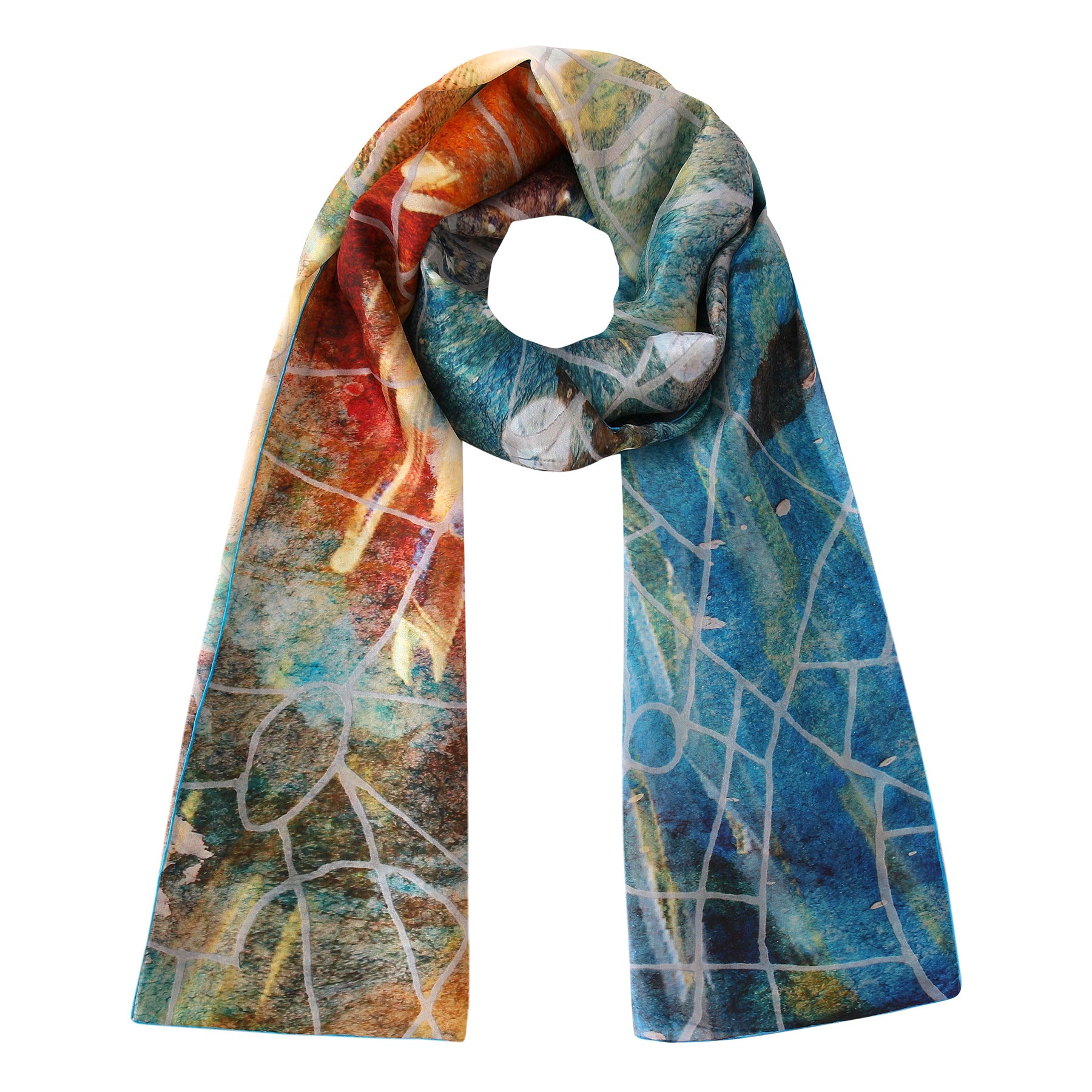 The Artisan Silk Scarf Estrellas del Templo features an artistic abstract pattern in vibrant blue, green, red, orange, and yellow with white intersecting lines. Loosely loop it at the top for a striking wearable artwork.