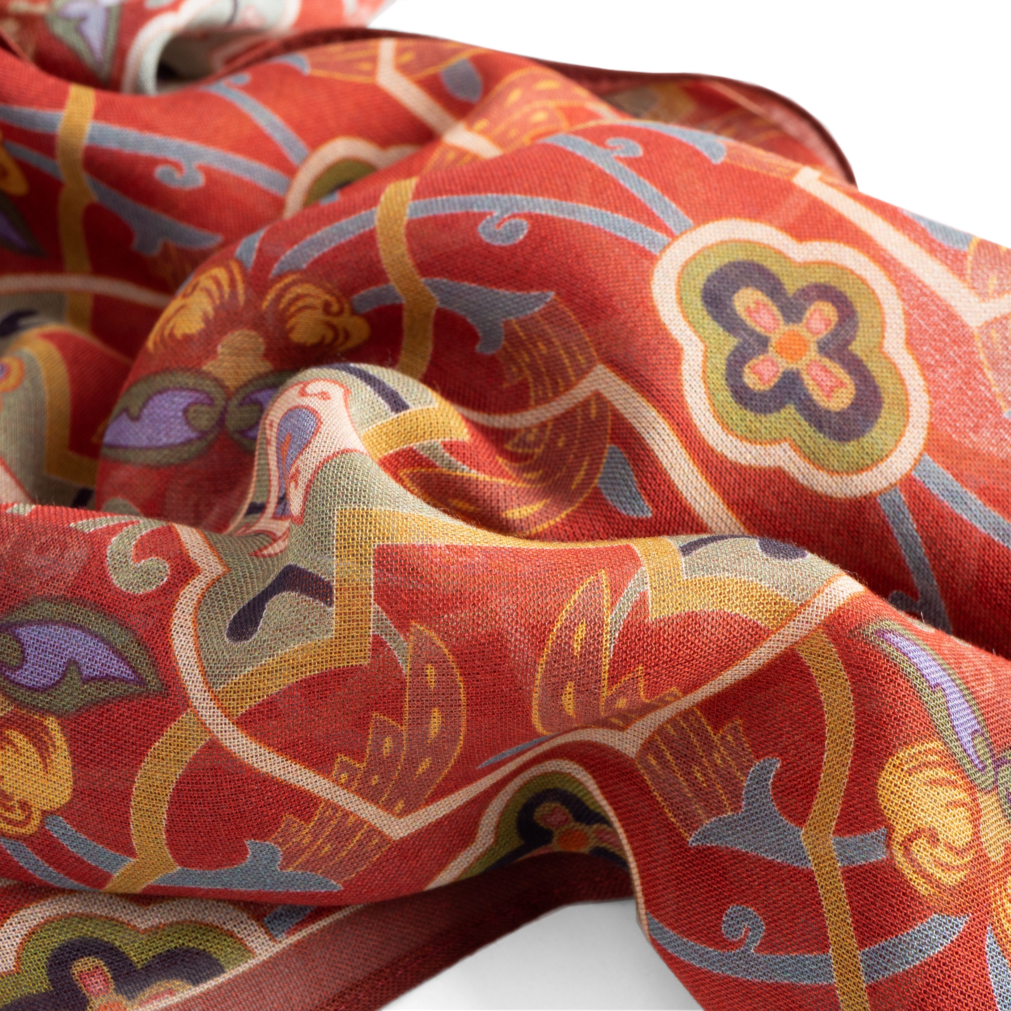 A close-up of the Red Scarf with Floral Print Samra, featuring intricate multicolored floral motifs and gold, yellow, purple, and grey geometric patterns, softly draped with gentle folds.