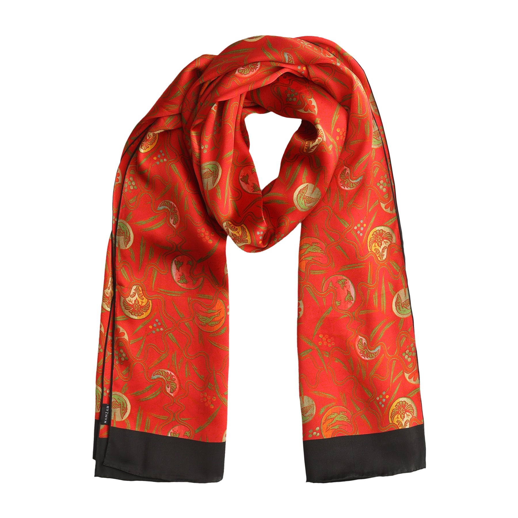 Draped red silk scarf showcasing playful green and gold organic patterns on a radiant crimson background.