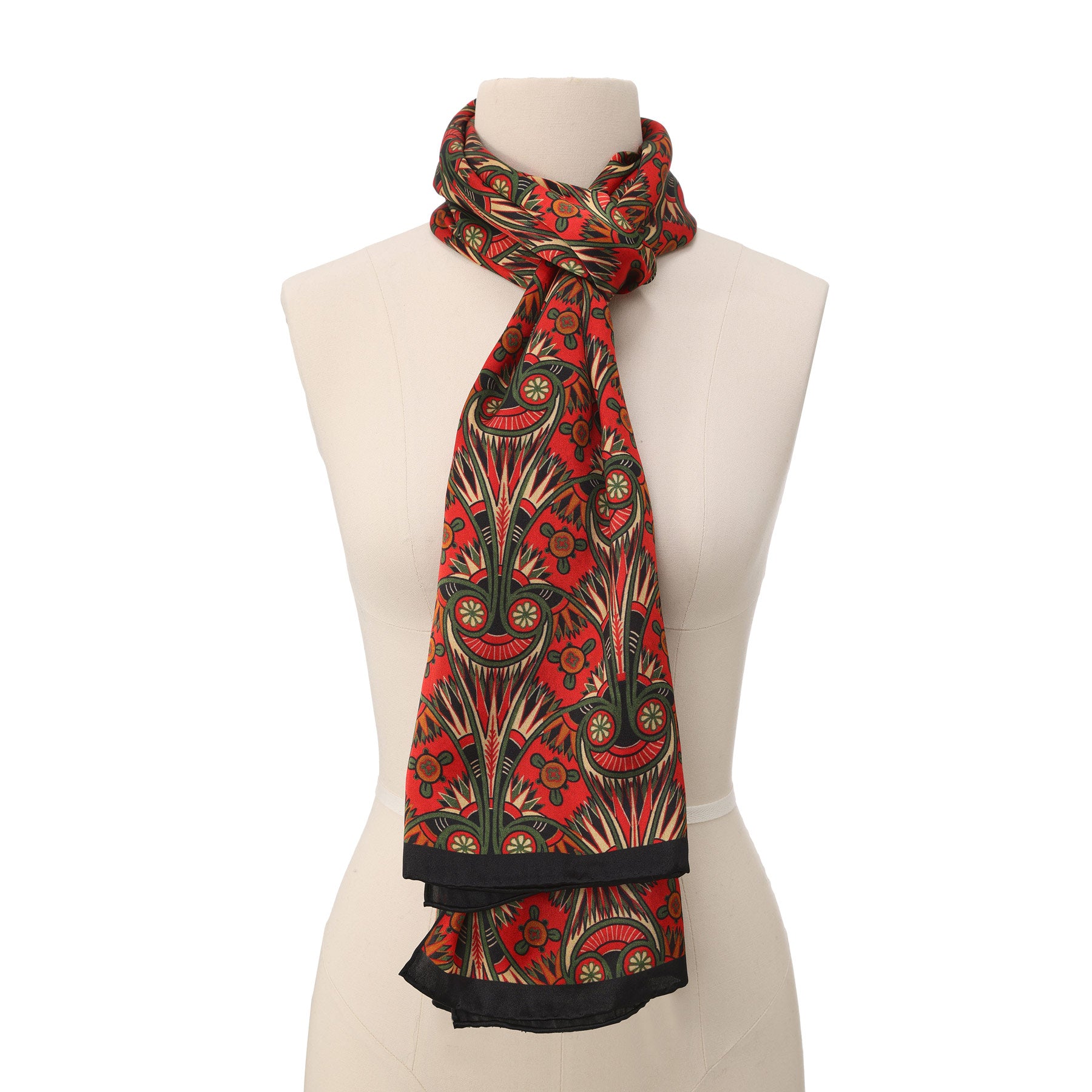 Swirled section of a red art nouveau scarf showcasing ornate green and gold floral elements in a vintage-inspired design.