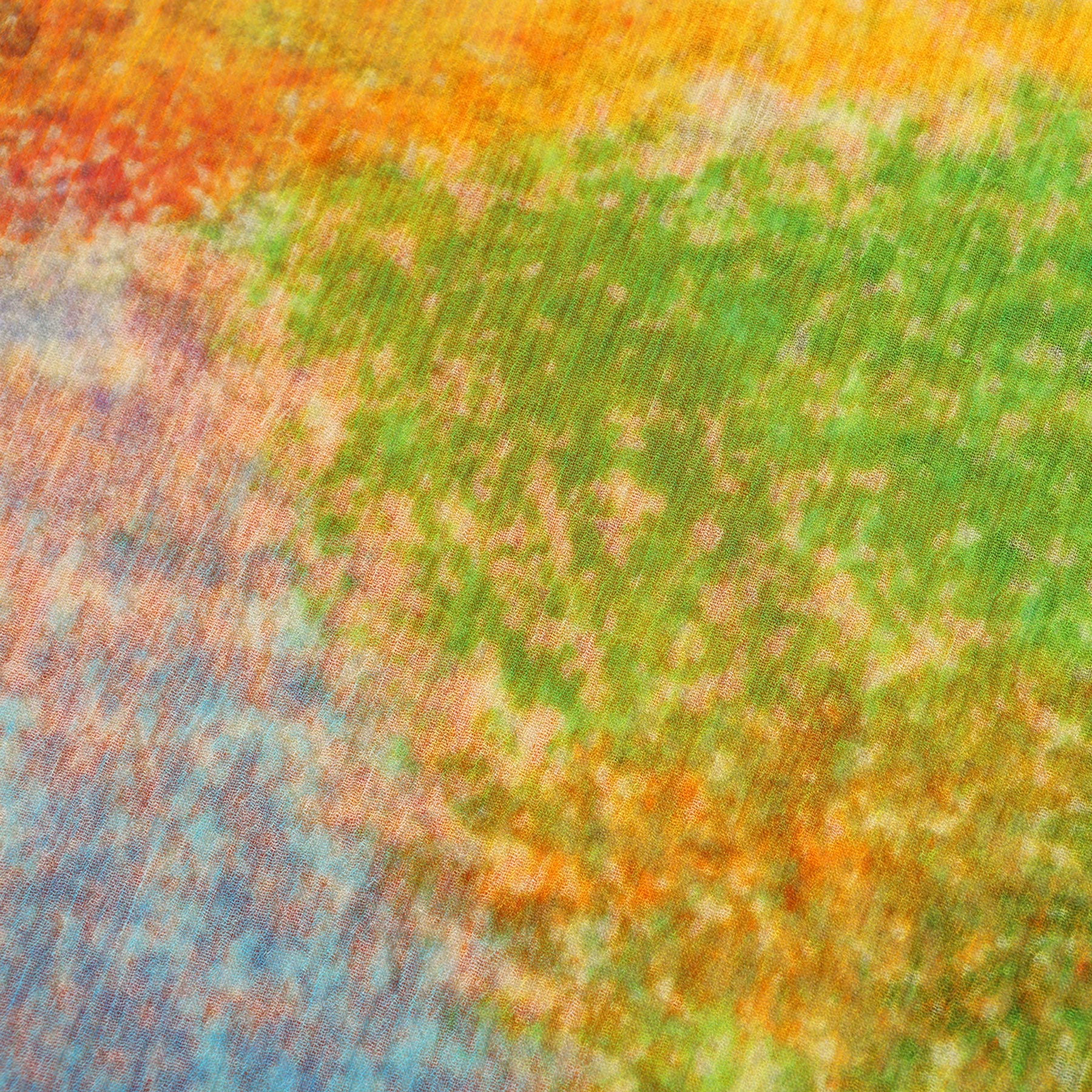 A close-up of the Multicolor Silk Scarf Calidoscopic reveals a vibrant abstract texture with blended green, orange, yellow