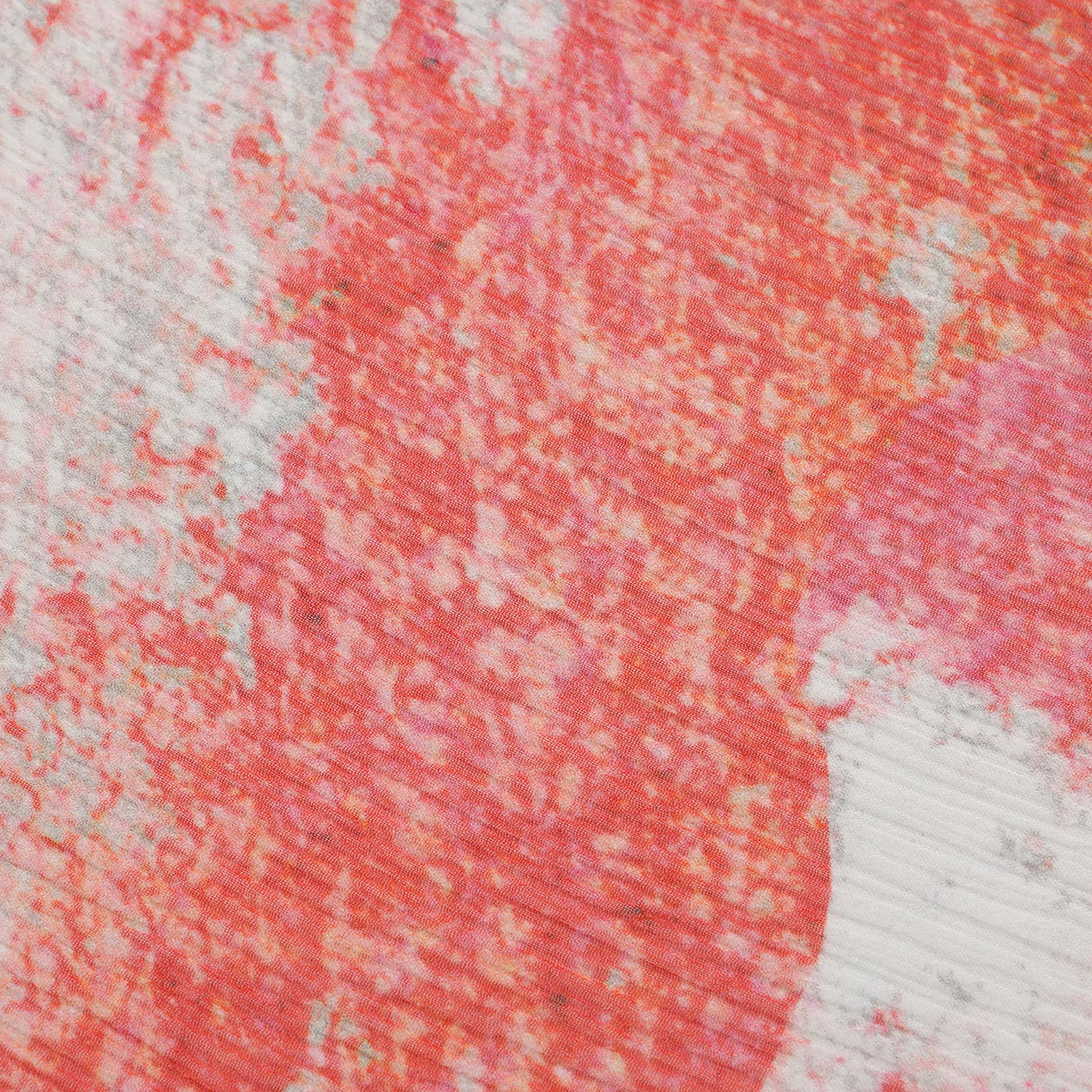 Close-up of the Multicolor Silk Scarf Fucsia Paradis, showcasing irregular red, pink, and white patterns for a modern, artistic look reminiscent of an abstract Mediterranean painting.