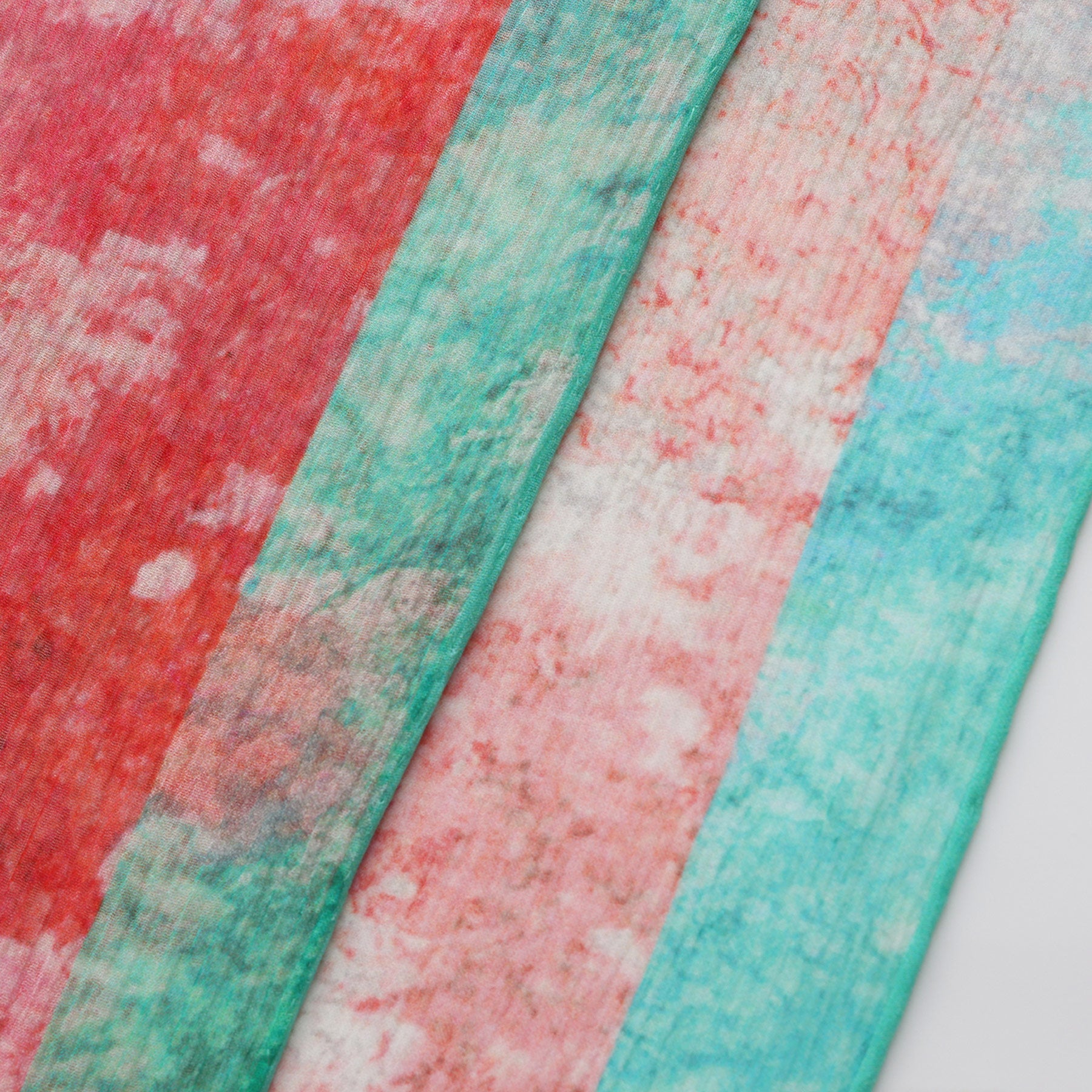 Close-up of three Multicolor Silk Scarf Fucsia Paradis pieces, each featuring unique marbled patterns in red, teal