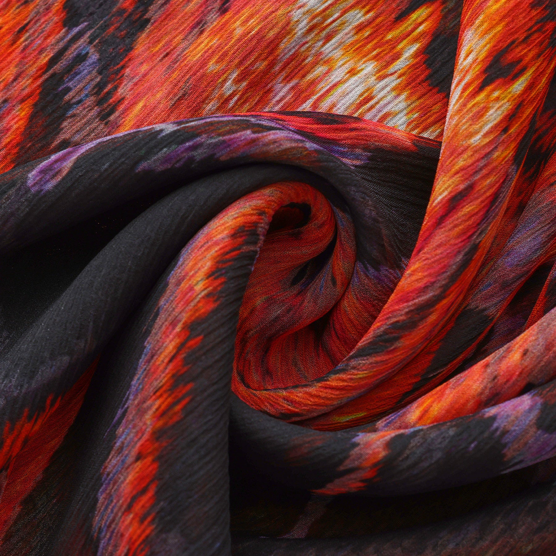 Close-up of the Black & Red Silk Scarf Anubis, featuring swirling textured muslin silk with vibrant shades of red, orange, black, and purple in an abstract fiery pattern—a striking piece of wearable art.