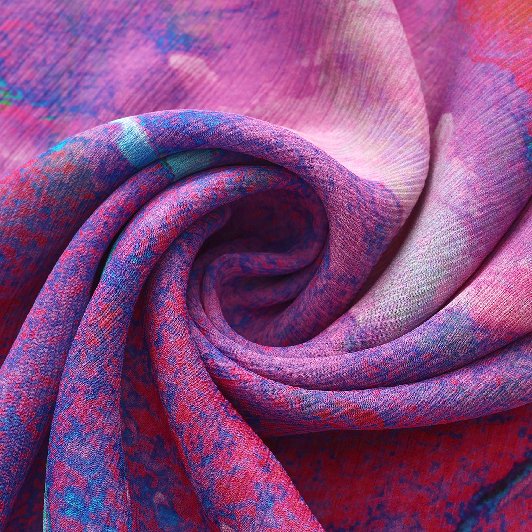 Close-up of the Multicolor Silk Scarf Océano Fucsia in vivid pink, purple, and blue, artfully spiraled.