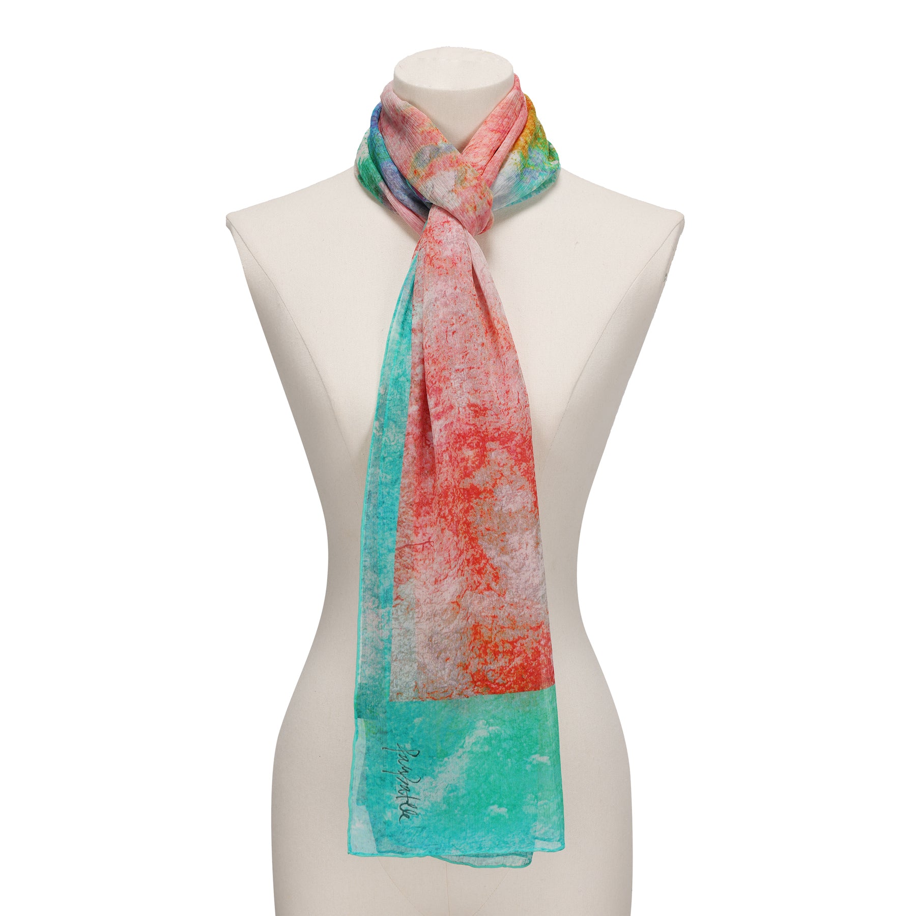 A mannequin showcases the Multicolor Silk Scarf Fucsia Paradis, a muslin silk accessory featuring a vibrant abstract design in teal, red, orange, and yellow—wearable art ideal for any occasion.
