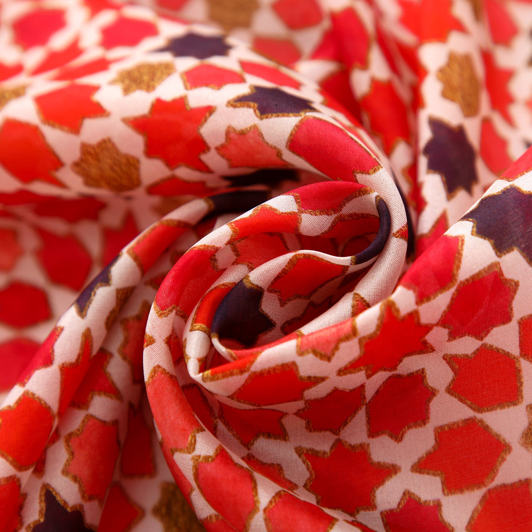 Close-up of the Red Silk Scarf with Islamic Art Print Alhambra, crafted from soft sheer silk and artistically folded to showcase its geometric mosaic pattern in red, gold, and dark purple—drawing inspiration from Andalusian designs.