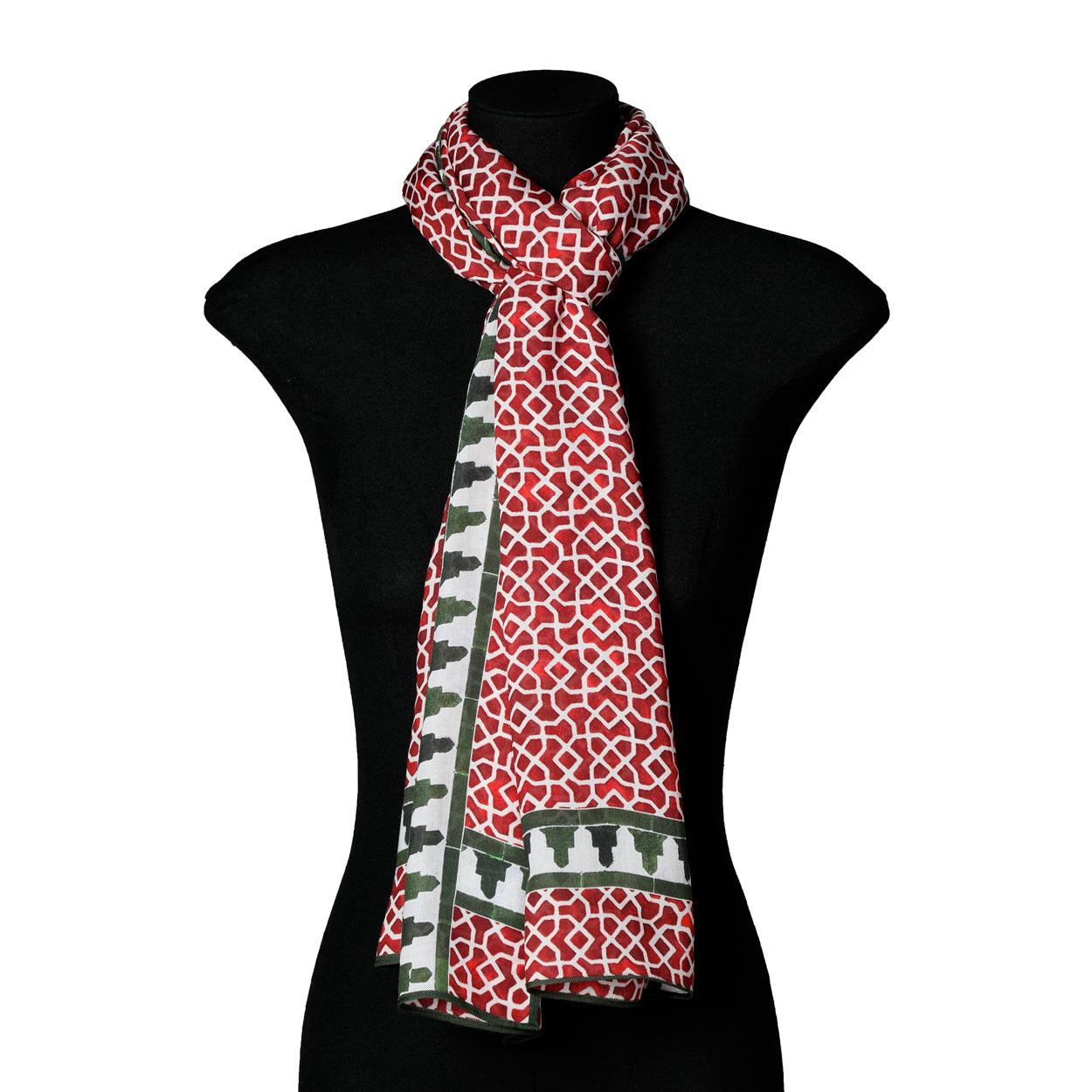 The Red and Green Scarf Islamic Art - Aziza Iqbal - Alcazaba Rojo, featuring red and white patterns with green and white borders inspired by Islamic geometric motifs, is draped around the neck of a black mannequin bust.