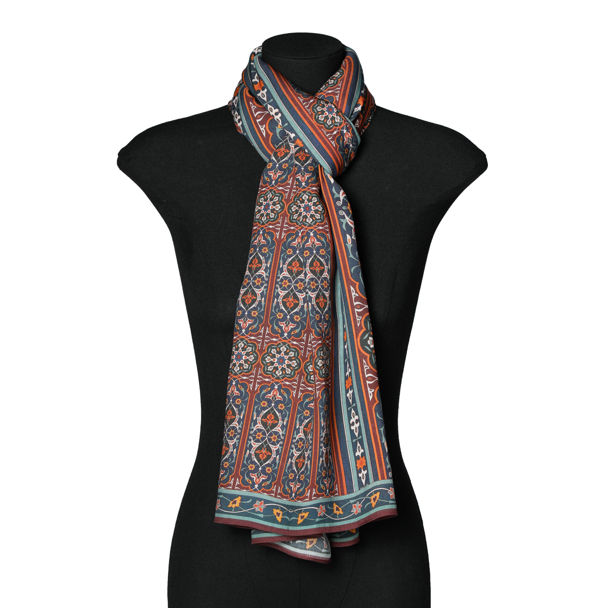 The Isfahan-Inspired Scarf by Zarashfan, crafted from 100% modal, features intricate floral designs in red, orange, blue, and cream and is elegantly draped on a black mannequin torso.